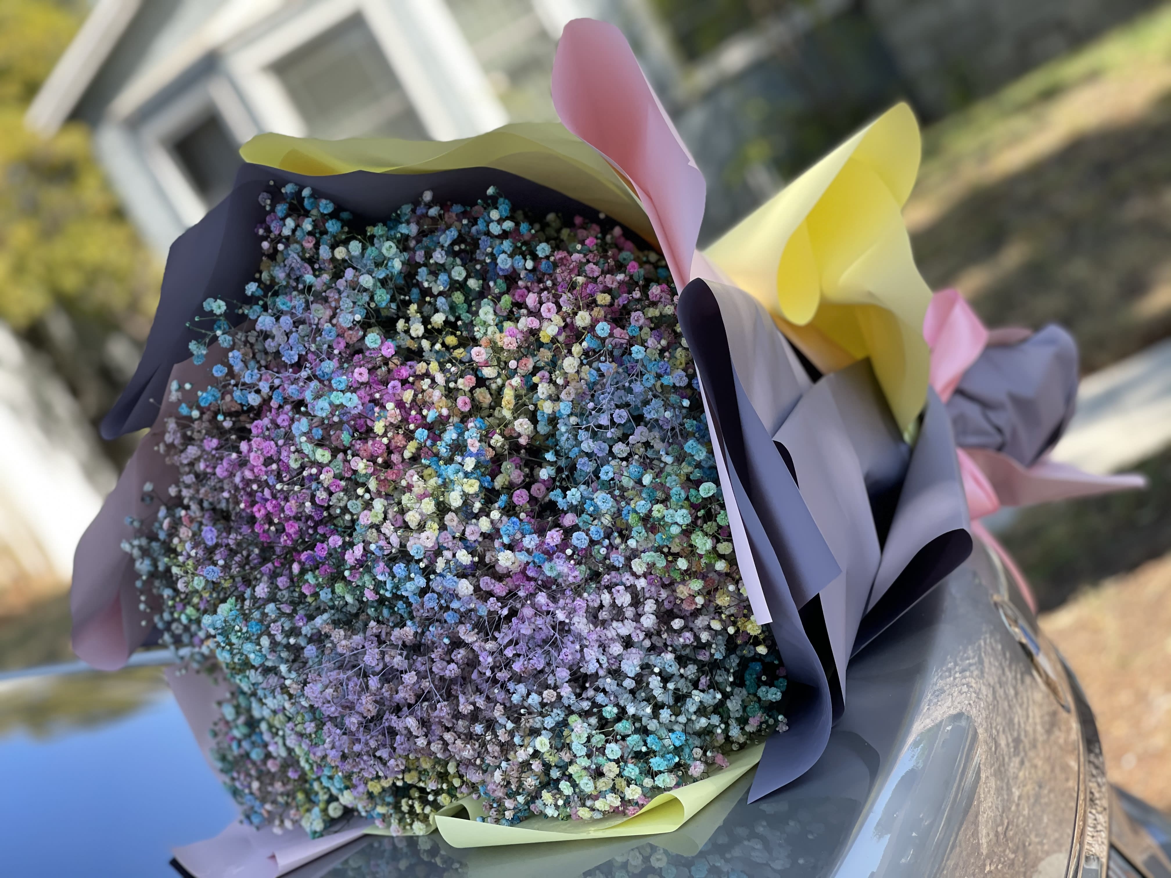 Bouquet of tiny multicolored flowers wrapped in pastel paper