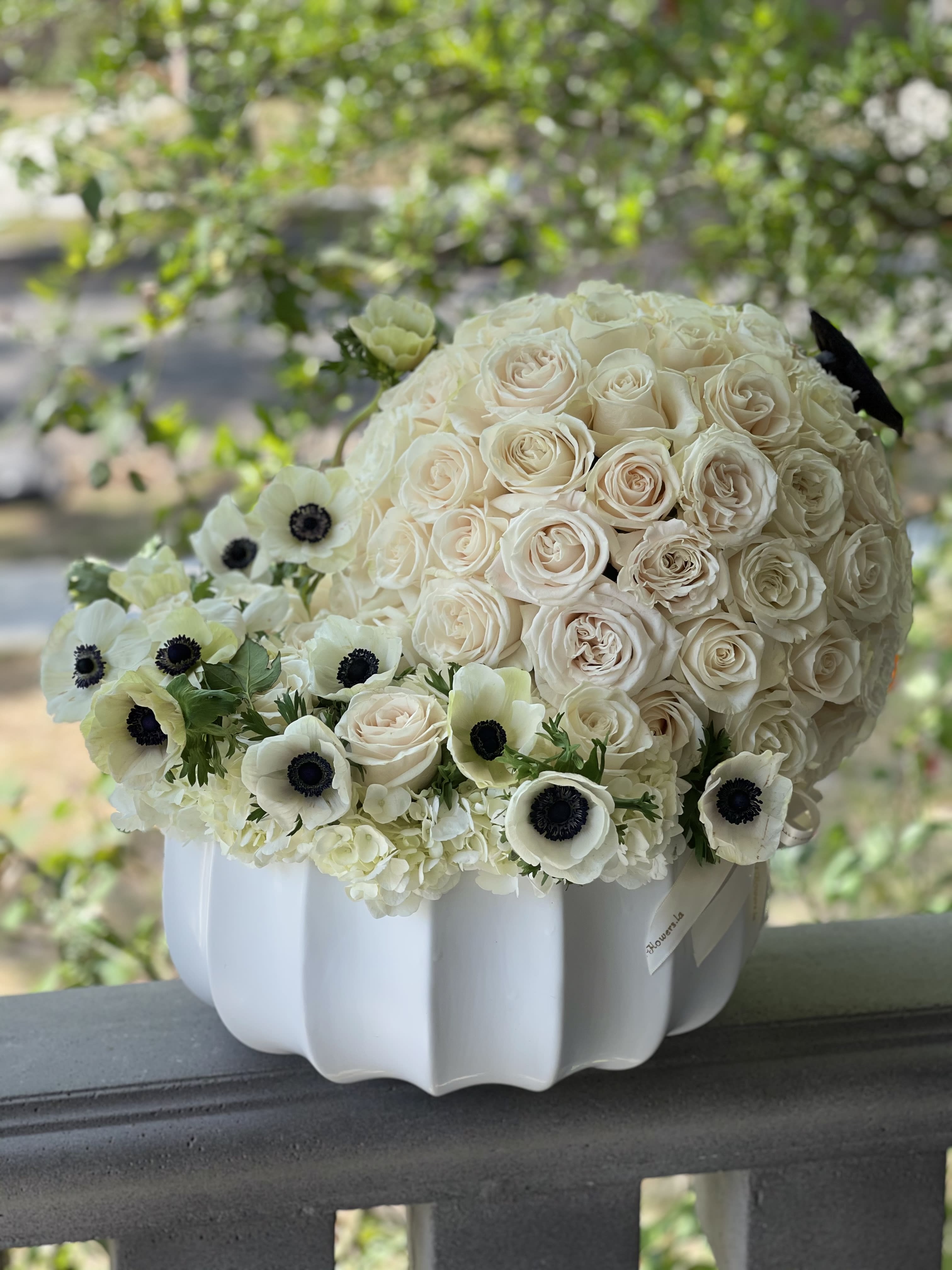 Cream rose bouquet with white anemones in a white vase