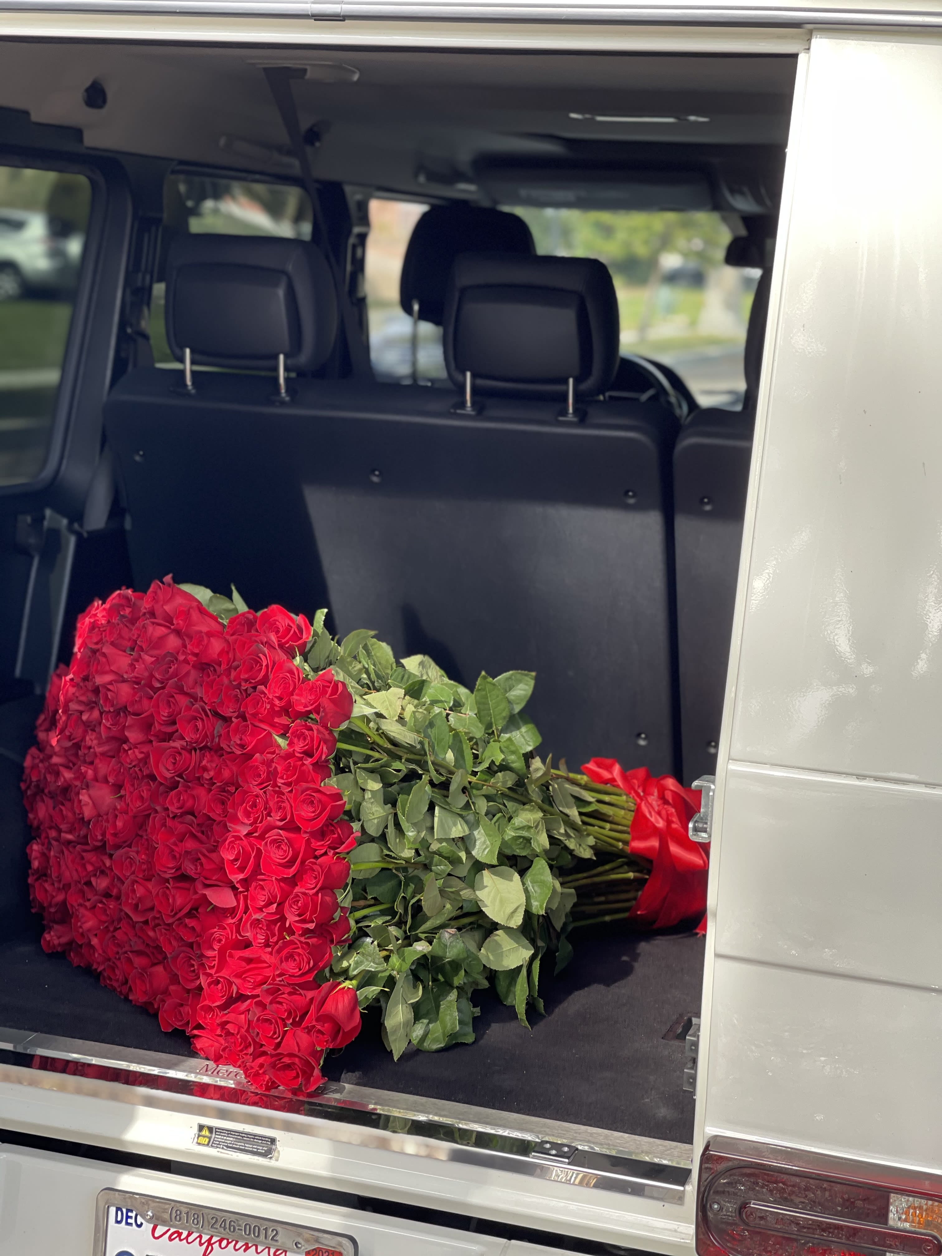 Large bouquet of red roses in the back of a vehicle