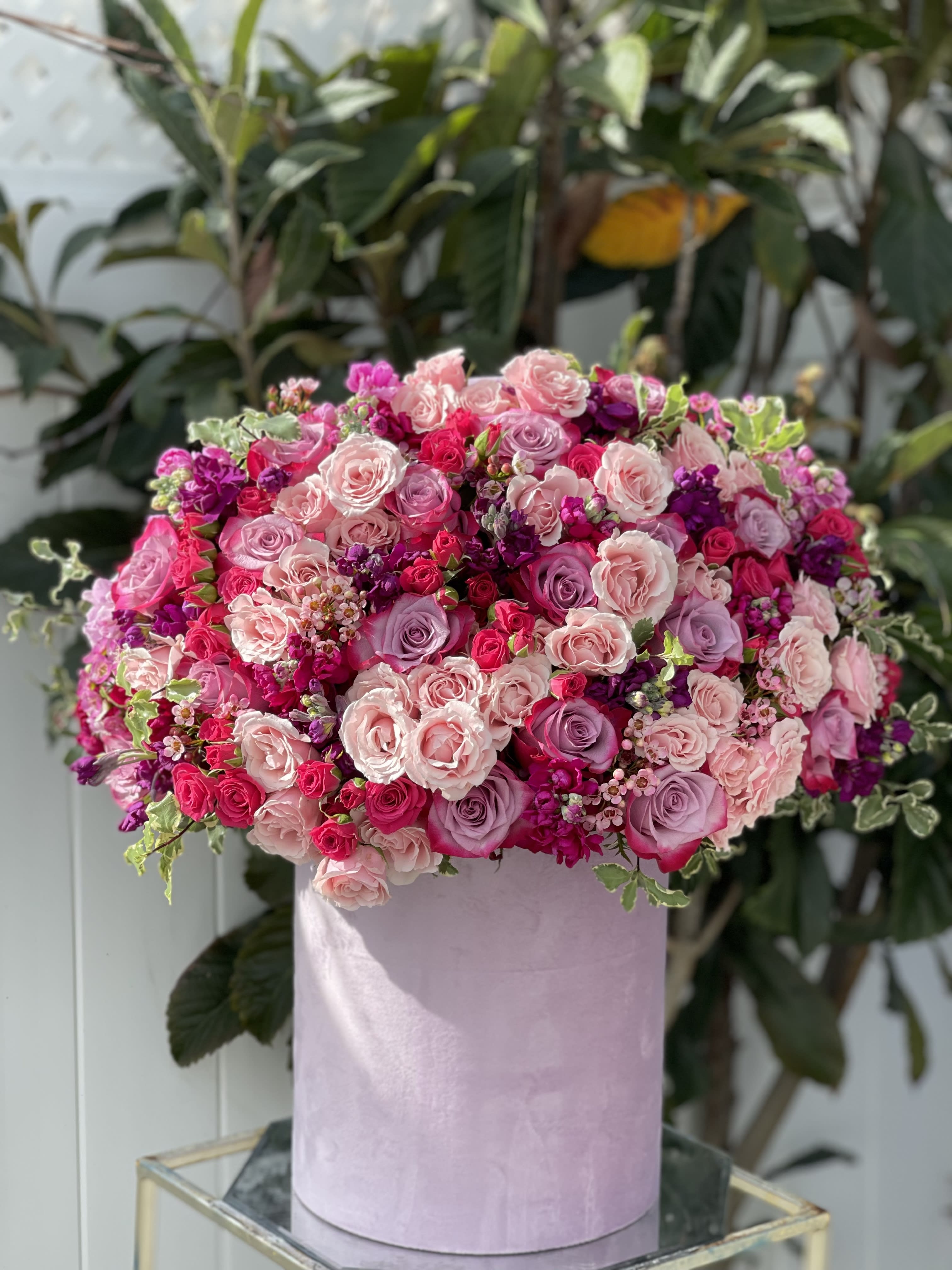 Pink and lavender rose arrangement in a pastel round box
