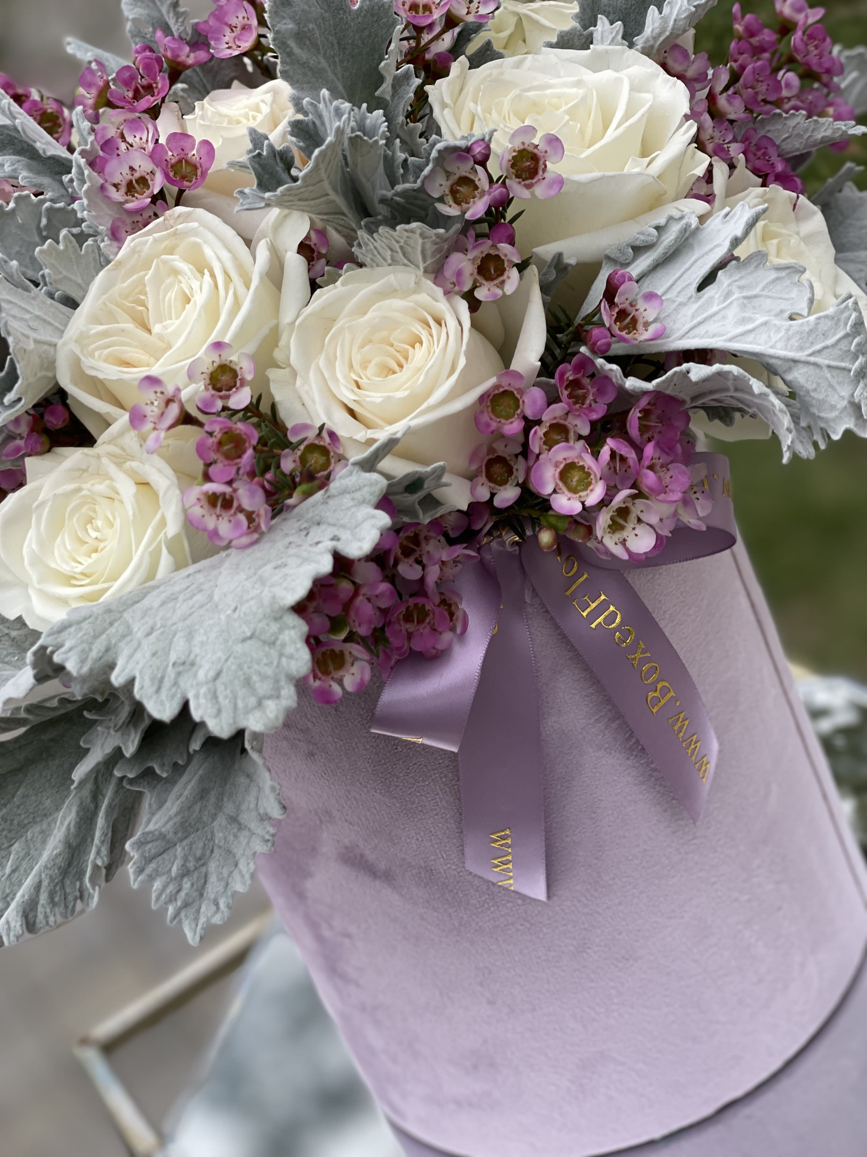 Lavander Fantasy - Lavander velvet box filled with “dusty miller” velvety leaves , white roses and wax flower.