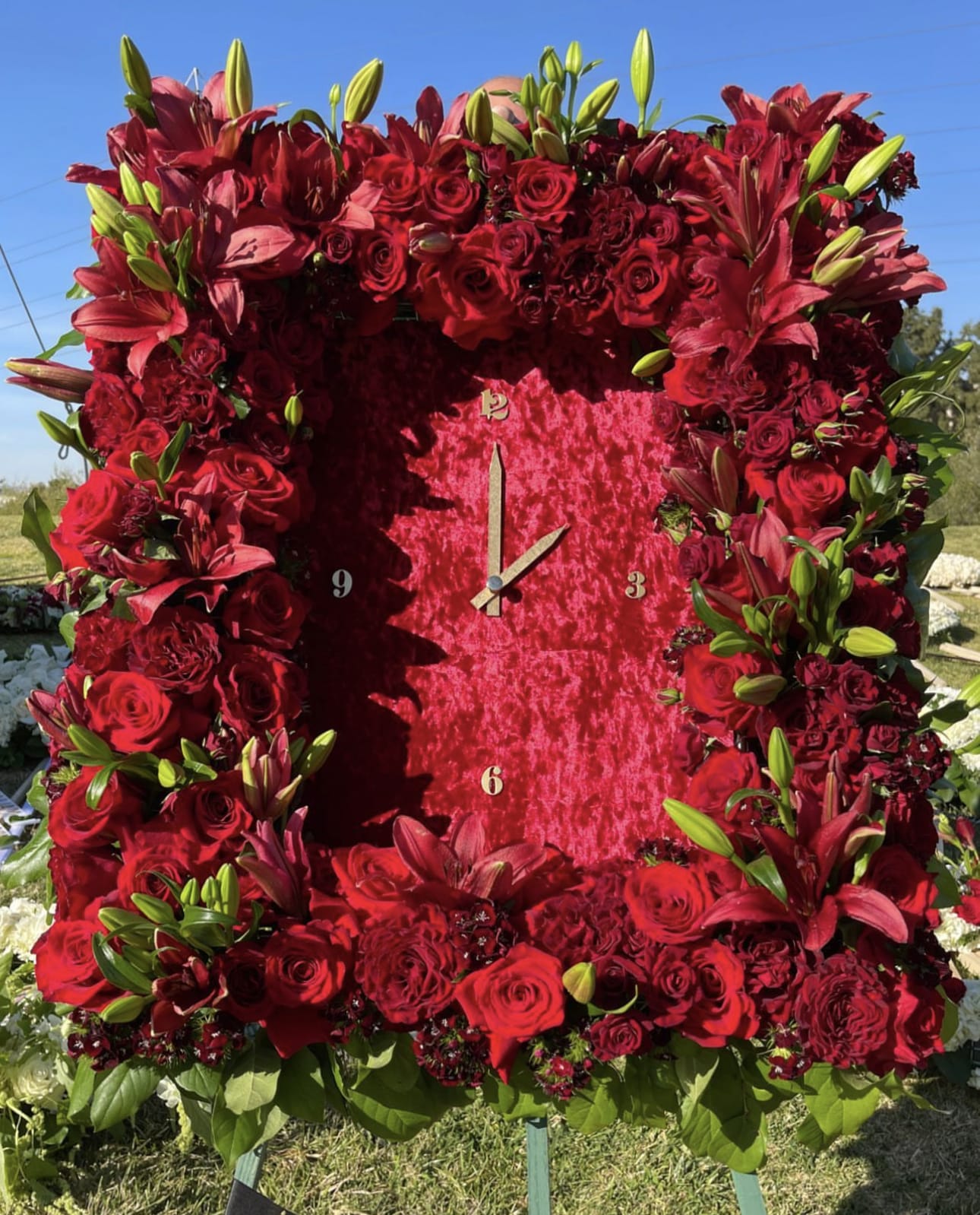 Large red floral clock covered in roses and lilies