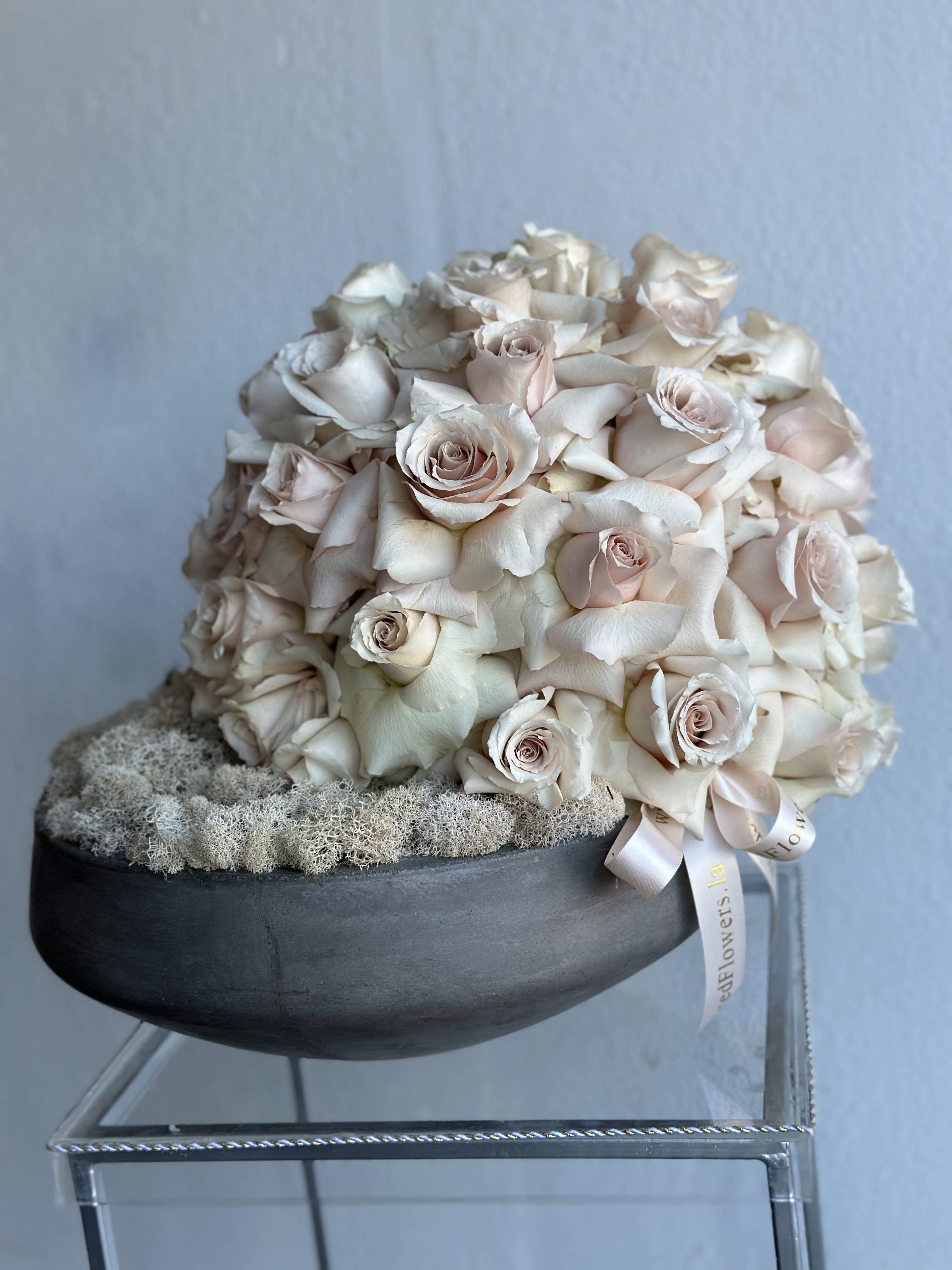 Cream rose bouquet in a black bowl with a ribbon
