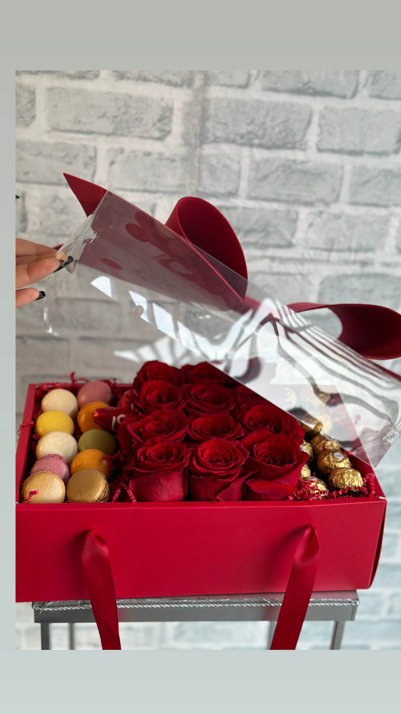 Red roses in a gift box with macarons and chocolates