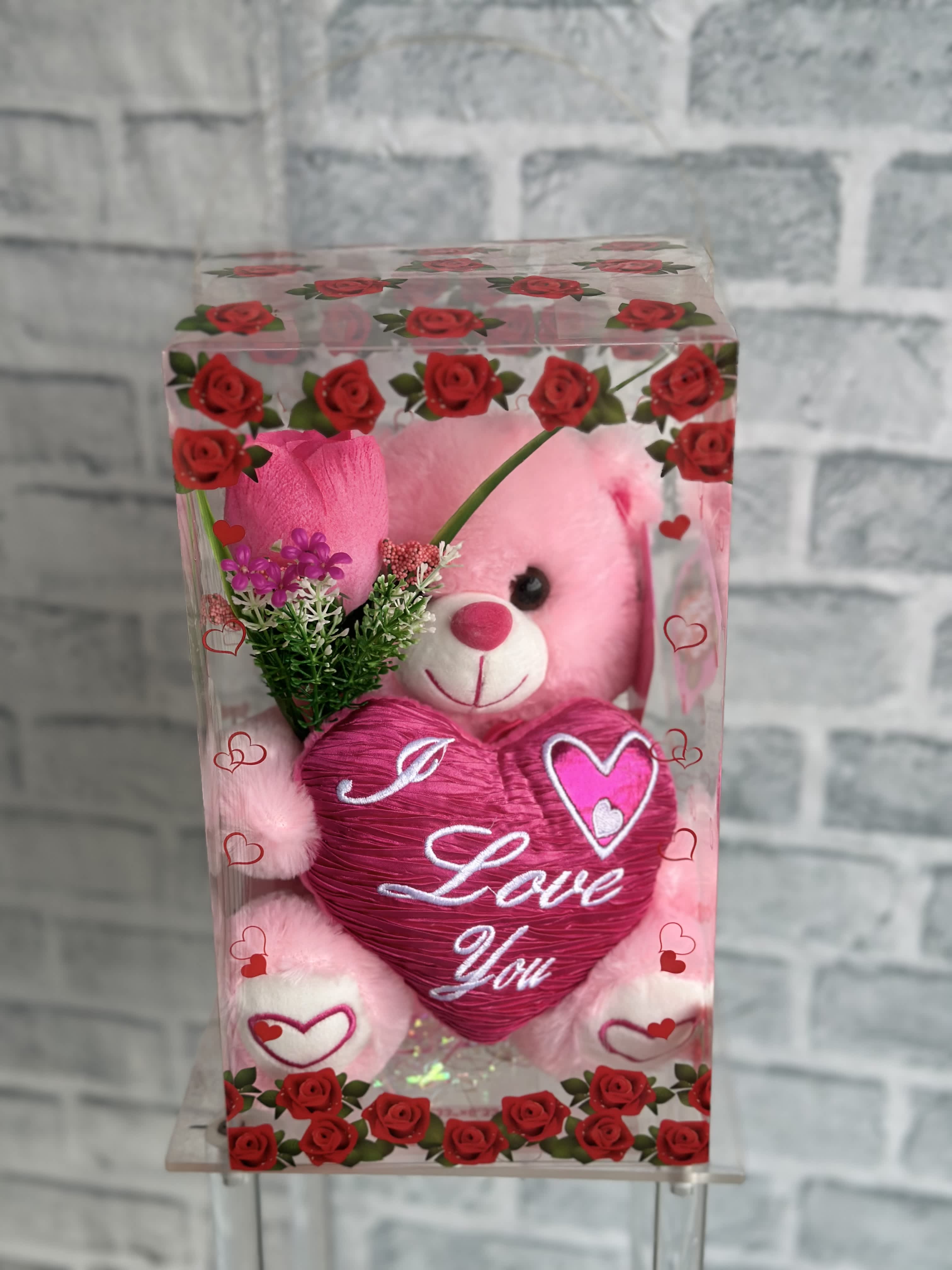 Pink teddy bear in a clear gift box with a heart-shaped "I Love You" decoration
