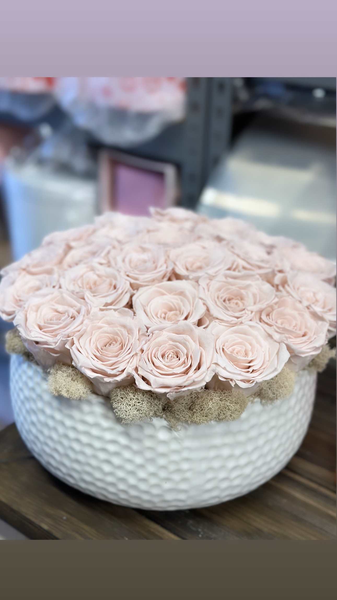 Pale pink roses arranged in a white textured bowl