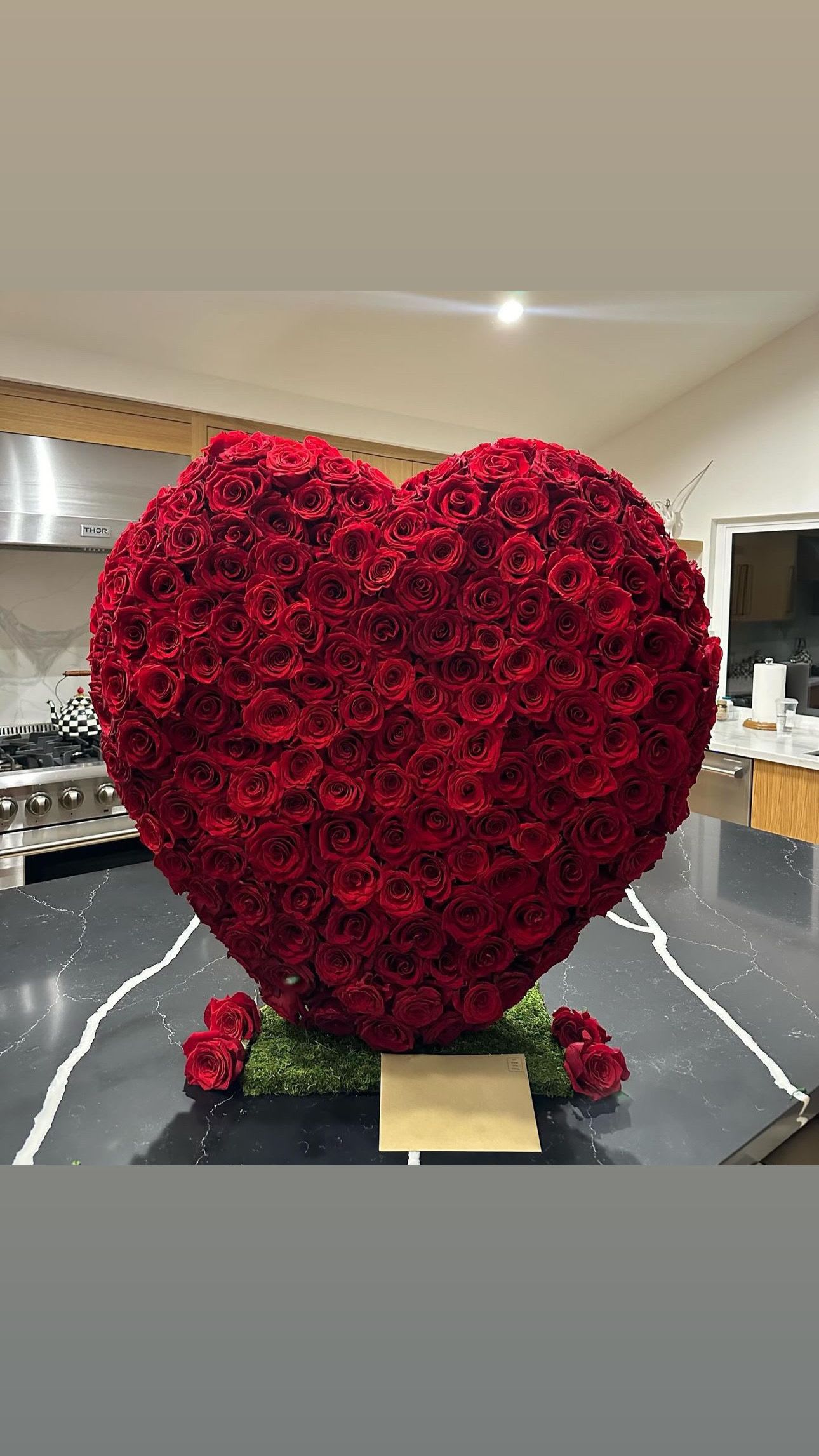 Heart-shaped arrangement of red roses on a kitchen counter