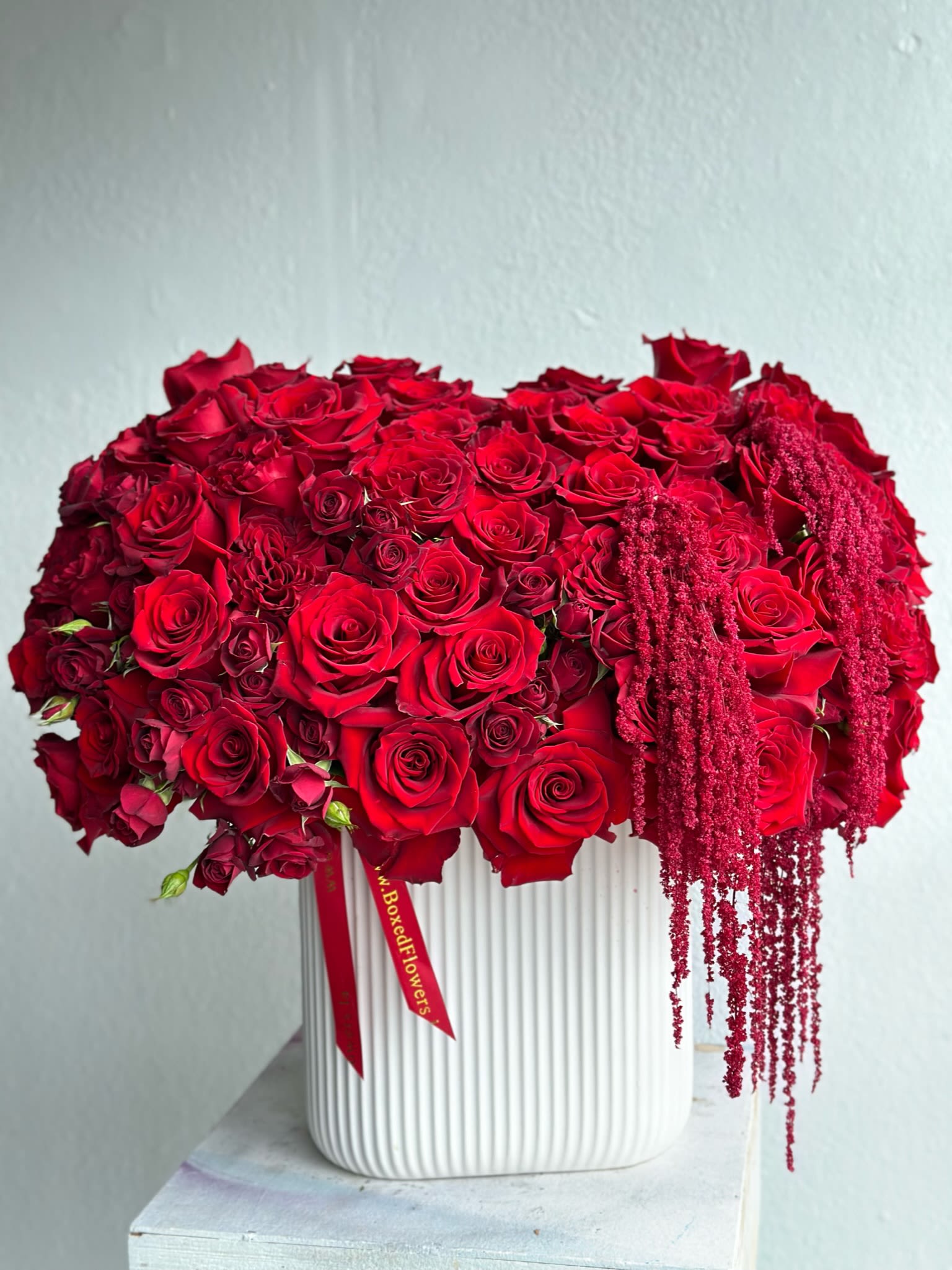 Drippy red ross - Red roses beautifully styled in a tall vase de orated with drippy amaranthys.  You can select your own flower color by mentioning it in the special instruction sections at checkout. 