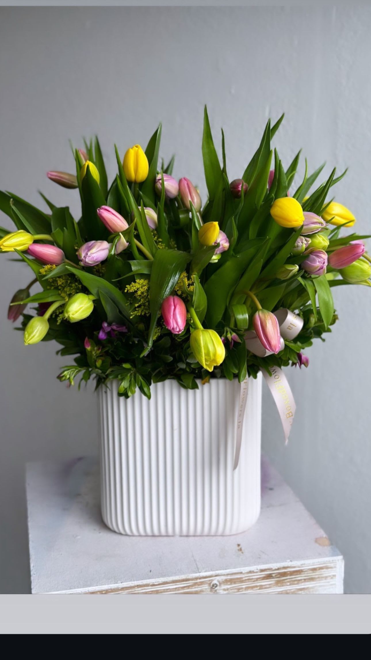 Mixed tulip bouquet in a white ribbed vase