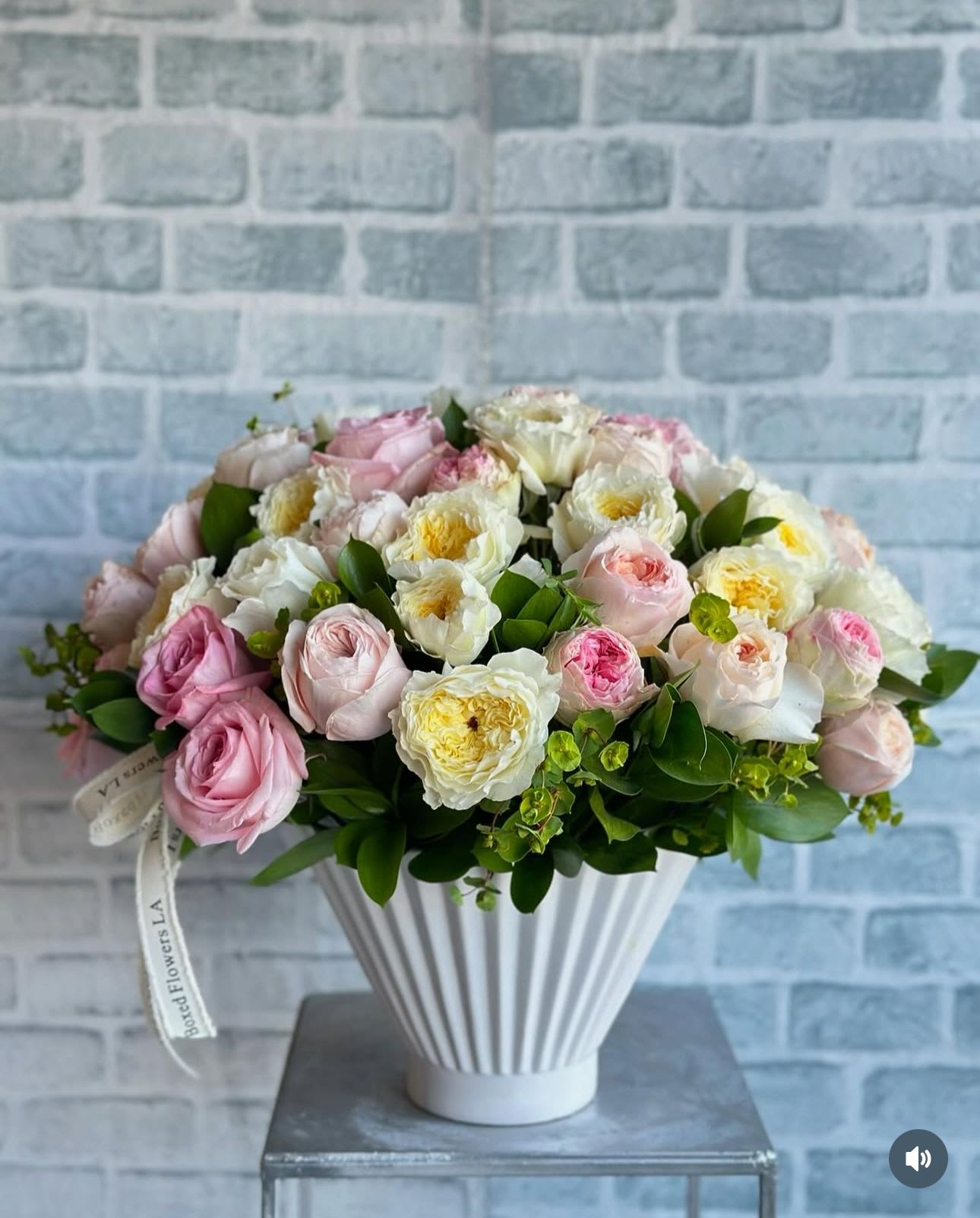 Pink and white rose bouquet in a white ribbed vase