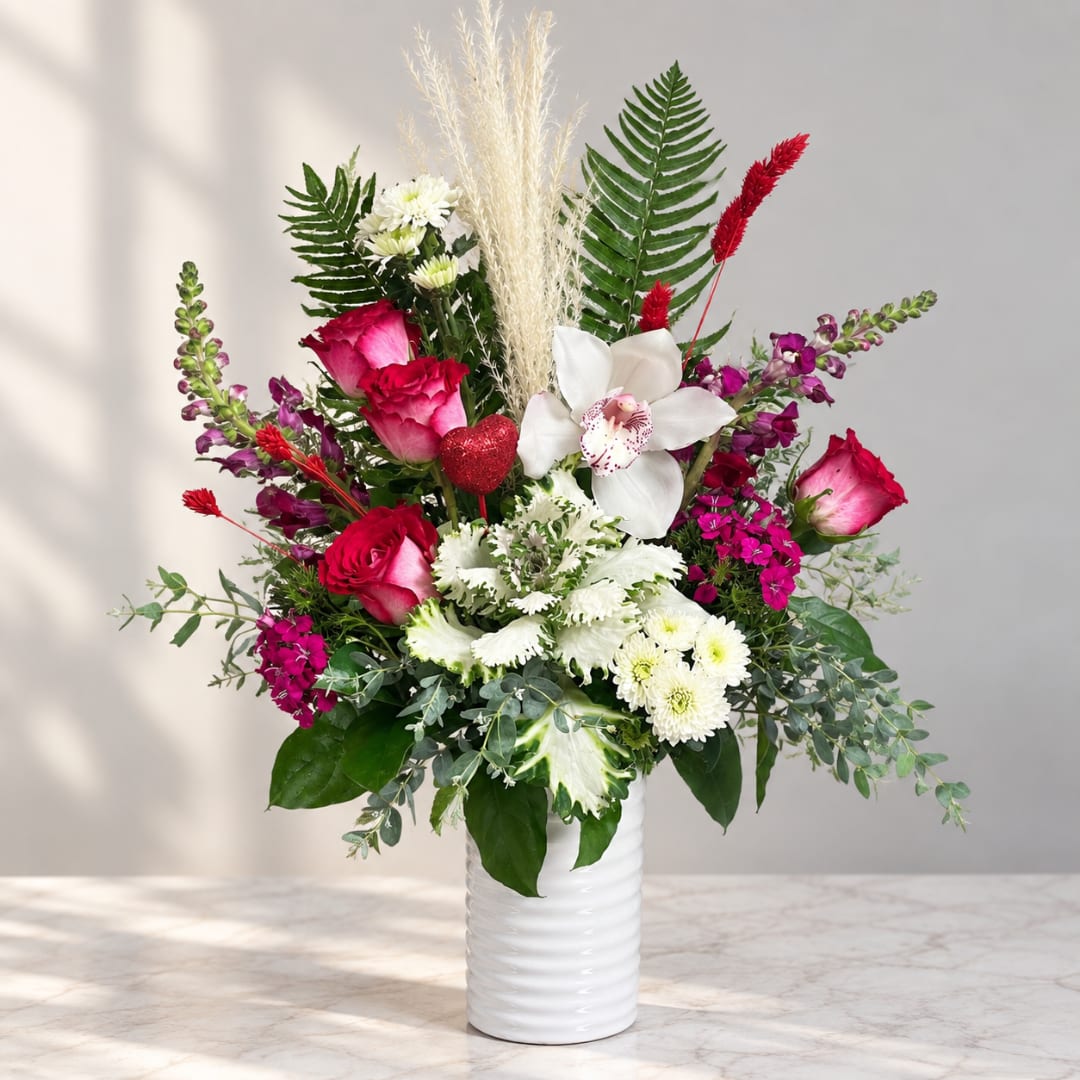 Pink and white mixed bouquet in a white vase with tall grasses