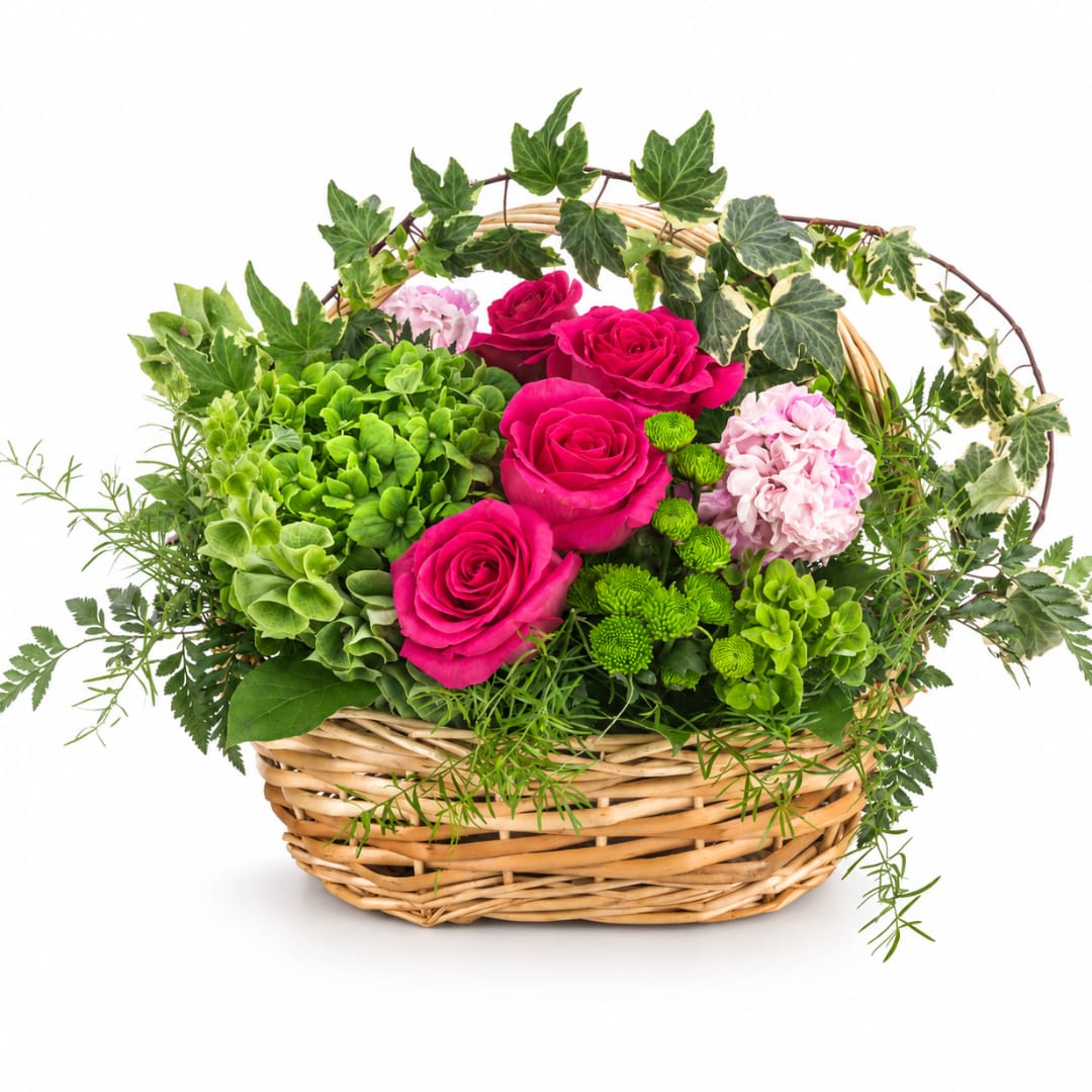 Pink roses and green hydrangeas in a wicker basket with ivy accents