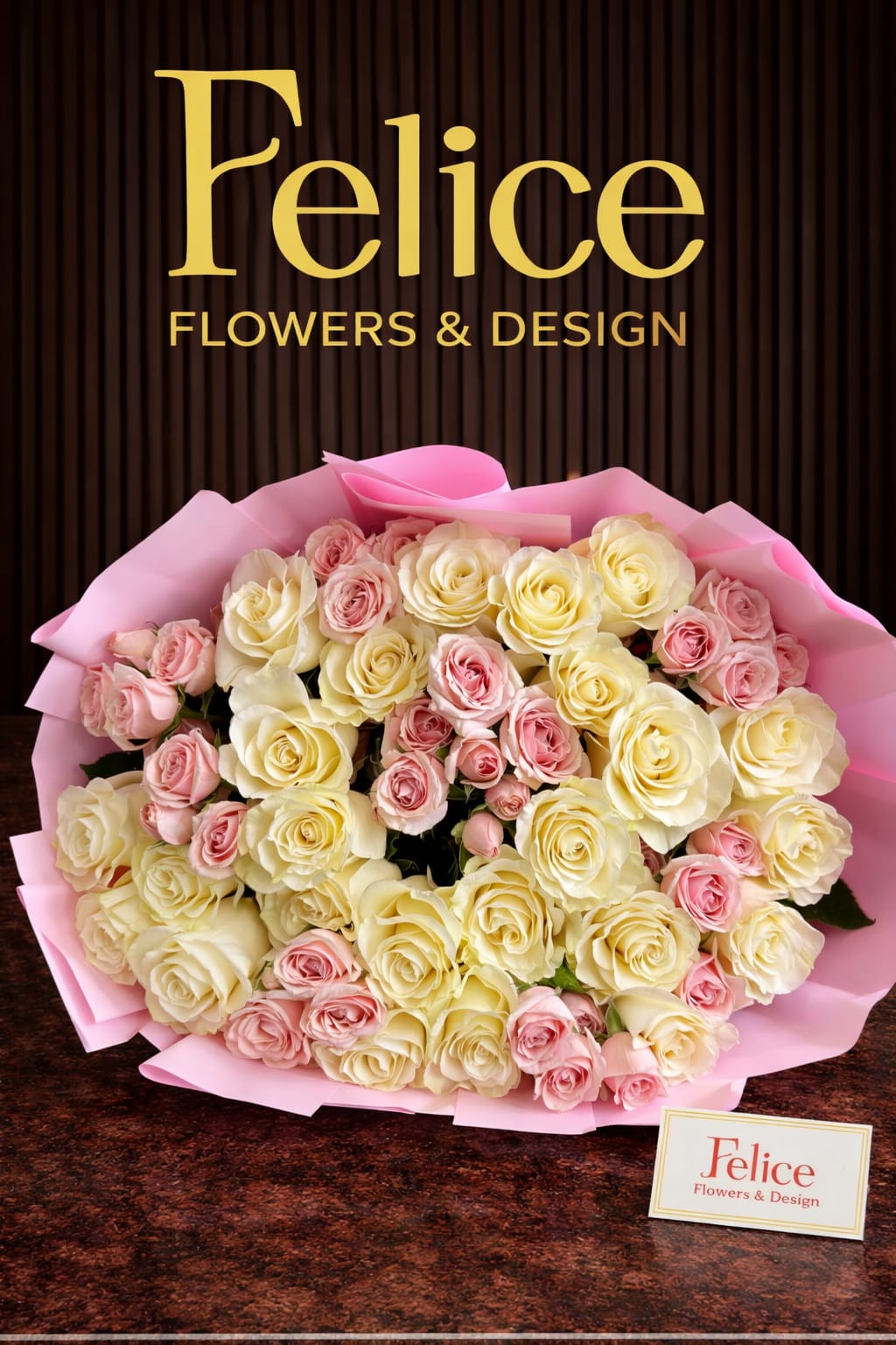 Bouquet of cream and pink roses wrapped in pink paper