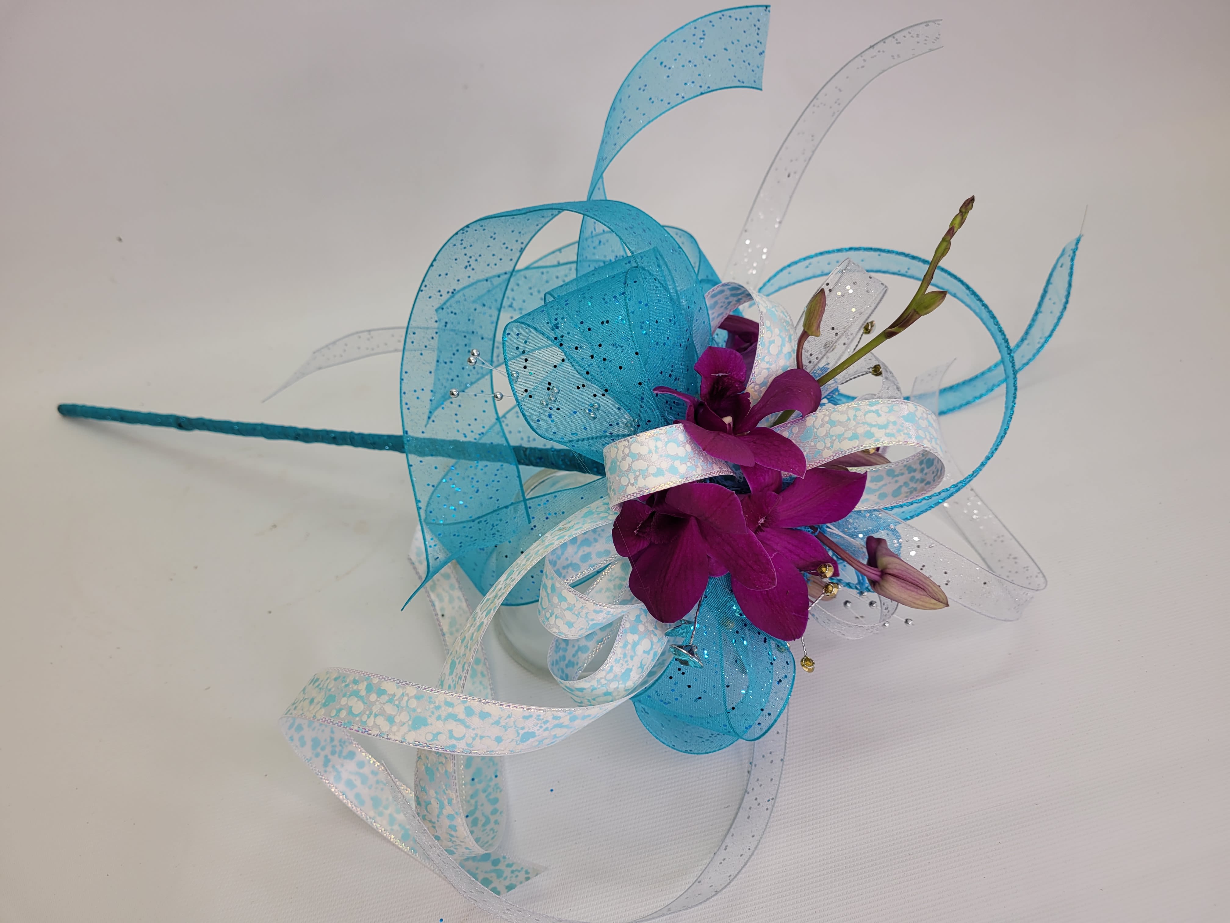 Purple orchid corsage with blue and white ribbon loops