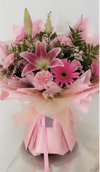 YOU'RE SPECIAL  - A love letter to pink — this exquisite all-pink bouquet is a perfectly coordinated collection of fragrant pink lilies (with budding stems that continue opening for days), a hot pink gerbera daisy, soft pink carnations, delicate waxflower, pink baby's breath, and lush fern, all wrapped in a dreamy layered pink tissue and satin bow. This the ultimate gift for the pink lover in your life. Ideal for birthdays, Valentine's Day, Mother's Day, bridal showers, or any occasion that deserves a truly show-stopping bouquet.