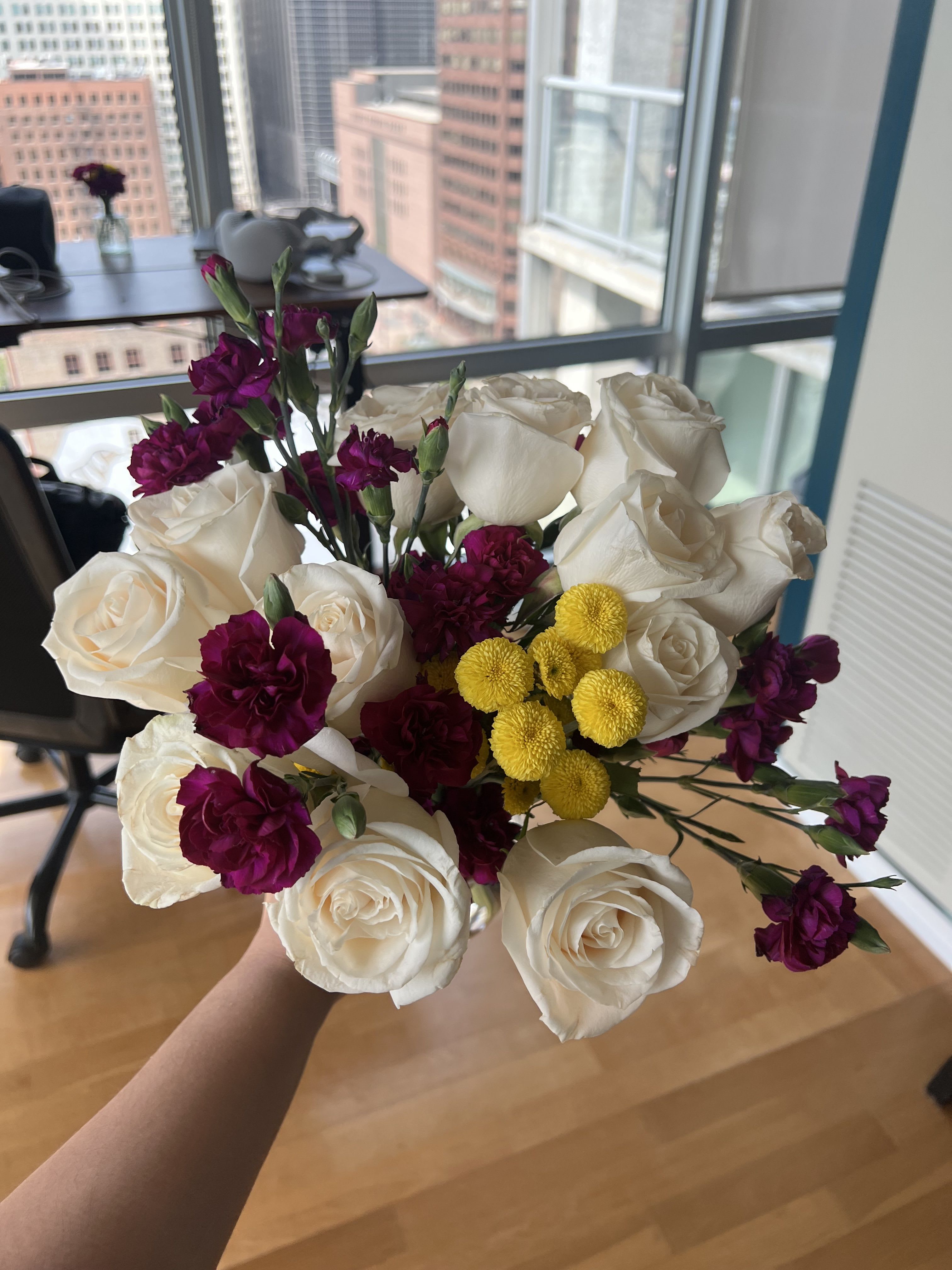 CONGRATULATIONS!! - Crisp white roses take center stage in this bold, sophisticated arrangement, accented by deep magenta carnations, vibrant yellow button mums, and delicate purple carnations. The striking contrast of ivory blooms against jewel-toned accents creates a bouquet that feels both classic and unexpected — equally at home in a boardroom, at a celebration, or as a heartfelt gift. A stunning choice for birthdays, congratulations, new beginnings, or any occasion worth remembering.