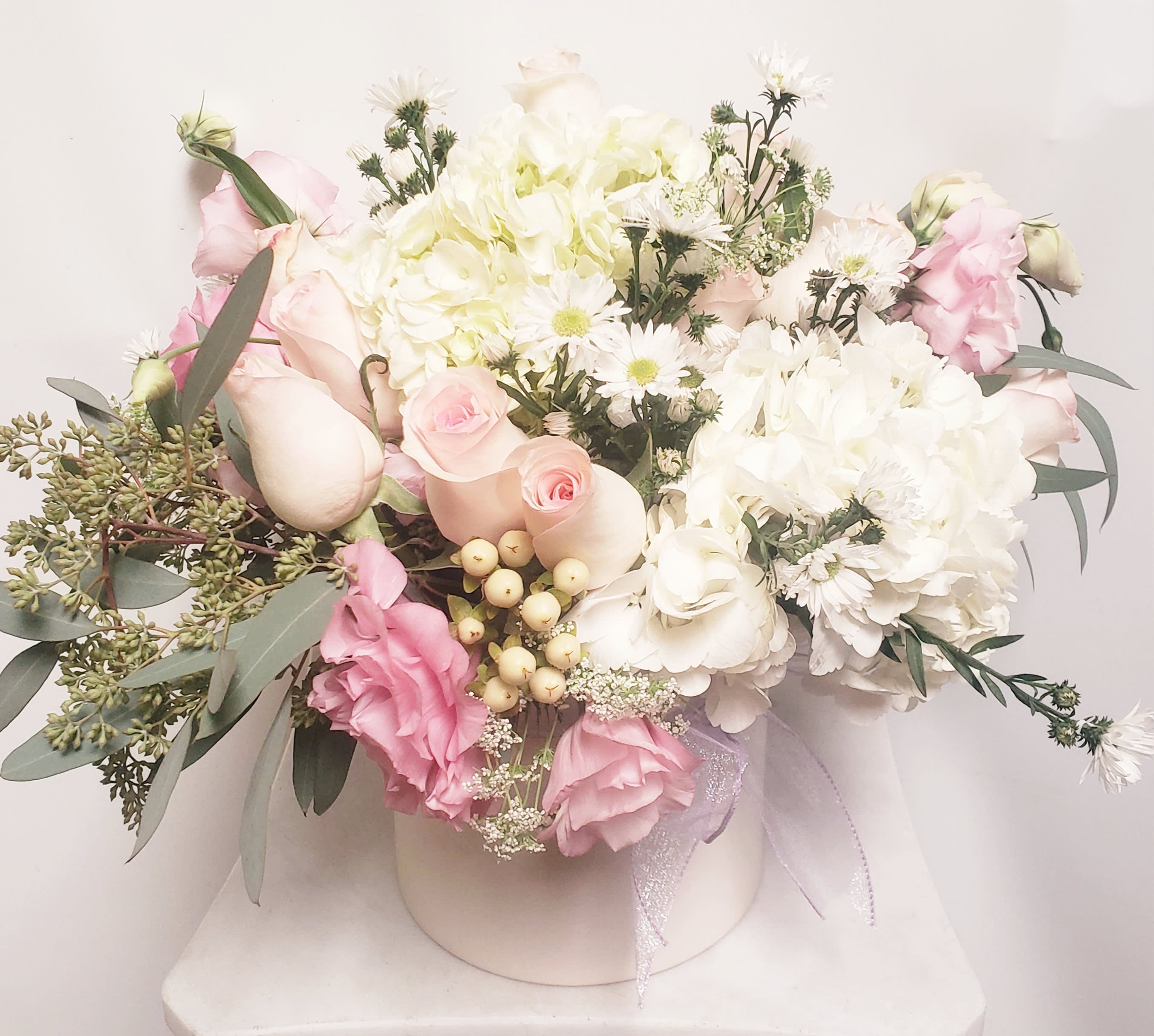 Pink and white bouquet in a round box with a ribbon