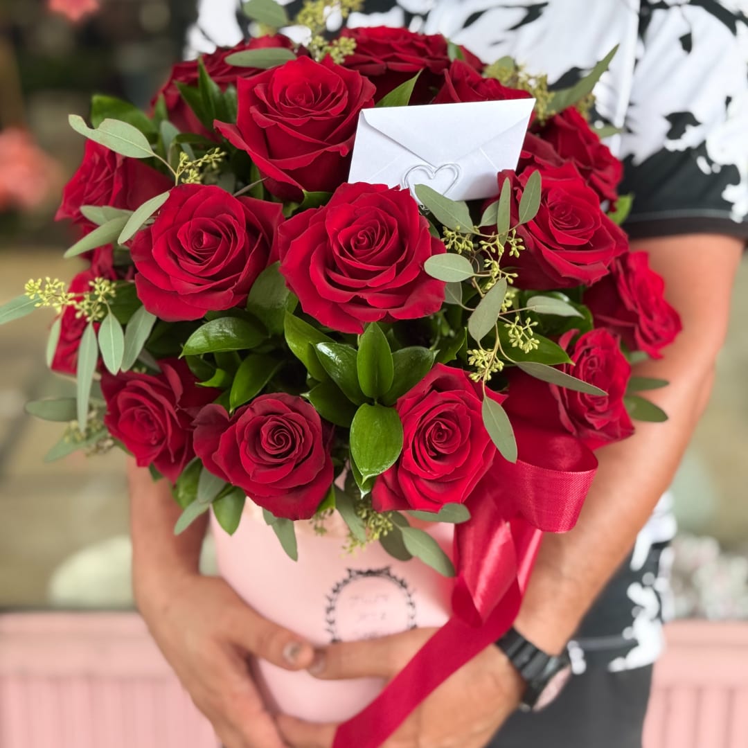 Bouquet of red roses in a pink box with a red ribbon