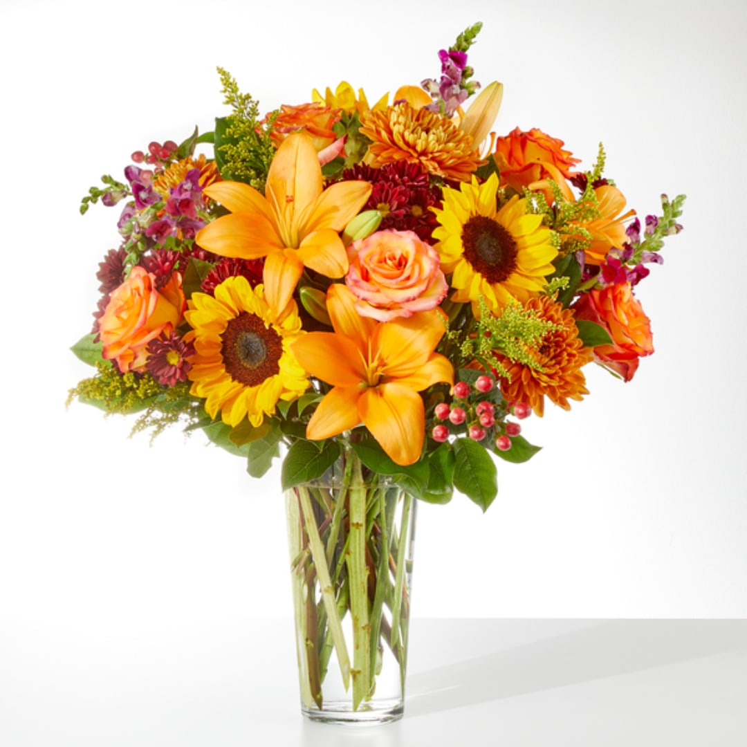 Orange and yellow mixed bouquet in a clear glass vase
