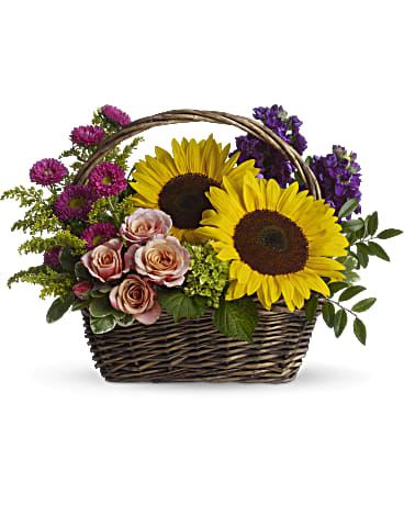 Basket arrangement with sunflowers, roses, and purple flowers