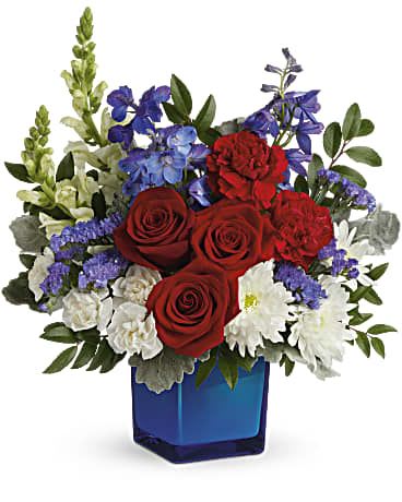 Red roses and white flowers in a blue glass vase