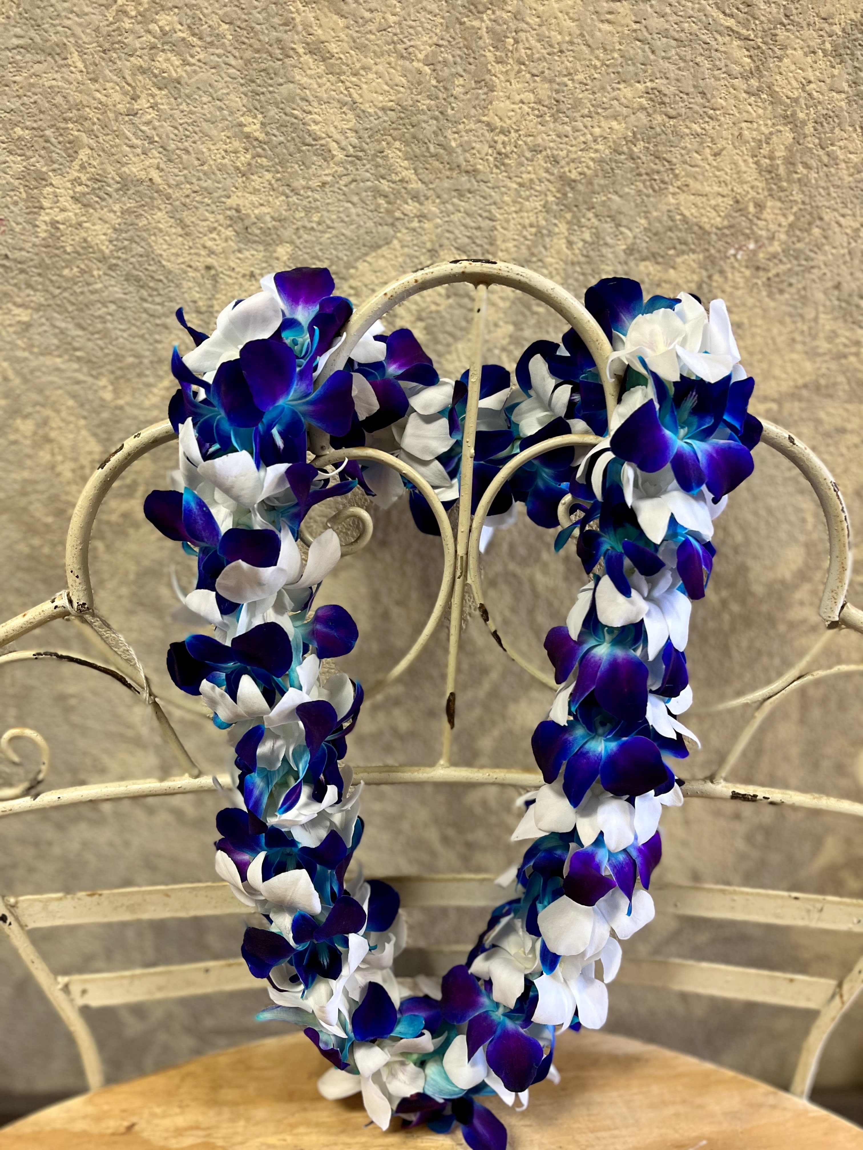 Blue and white flower lei draped over a metal chair