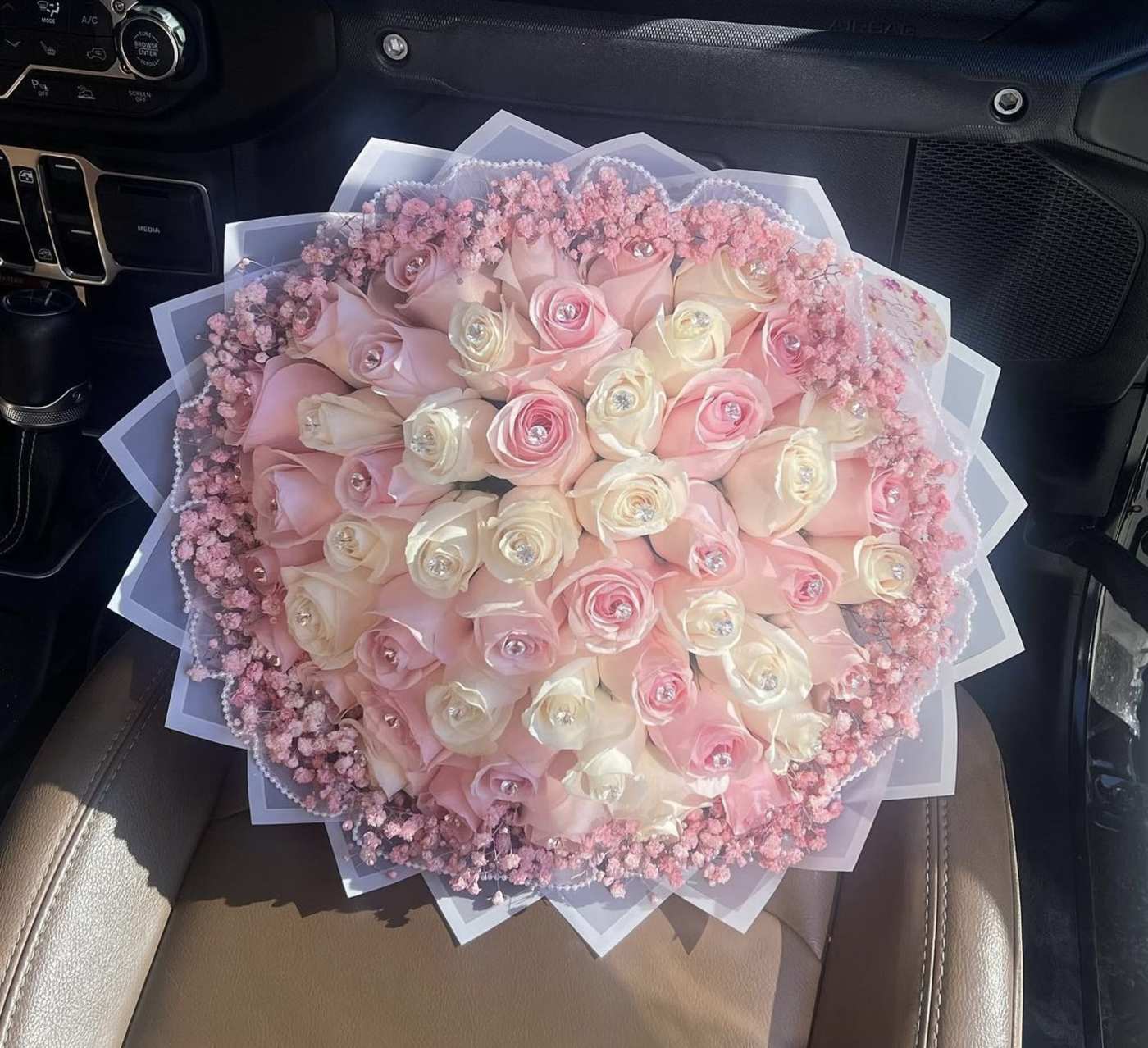 Round bouquet of pink and white roses with pink filler flowers
