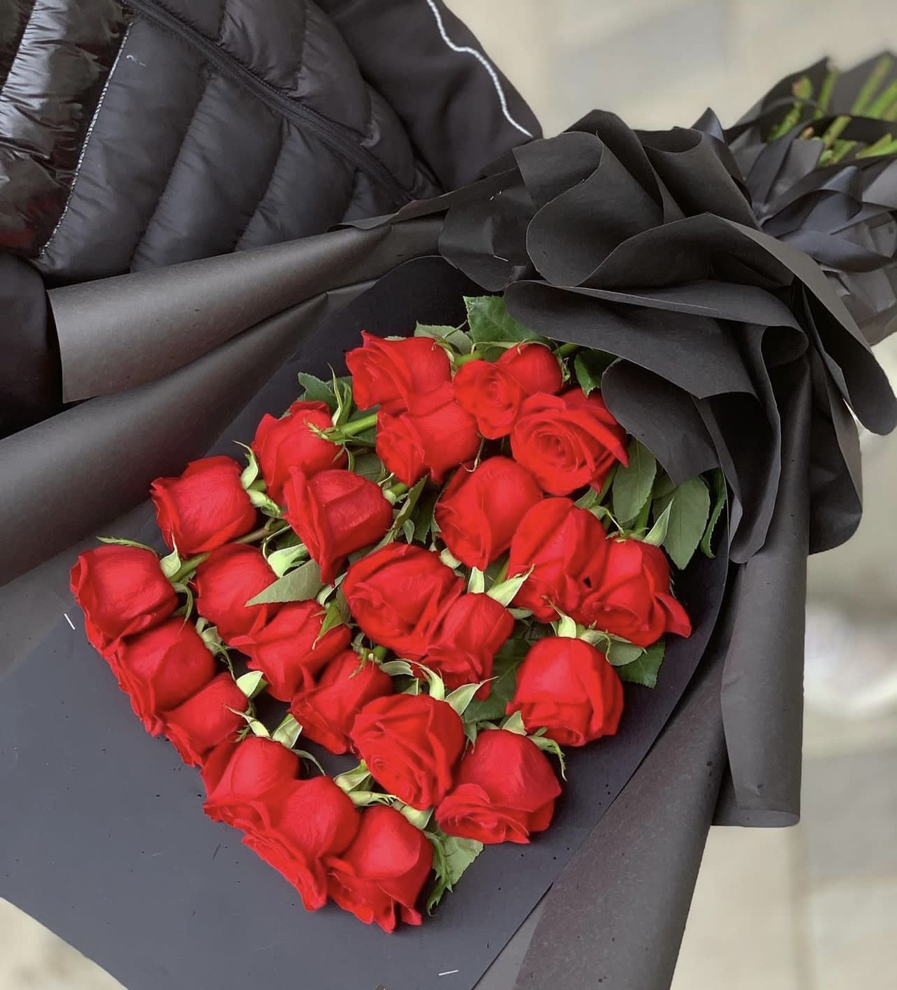 Bouquet of red roses wrapped in dramatic black paper