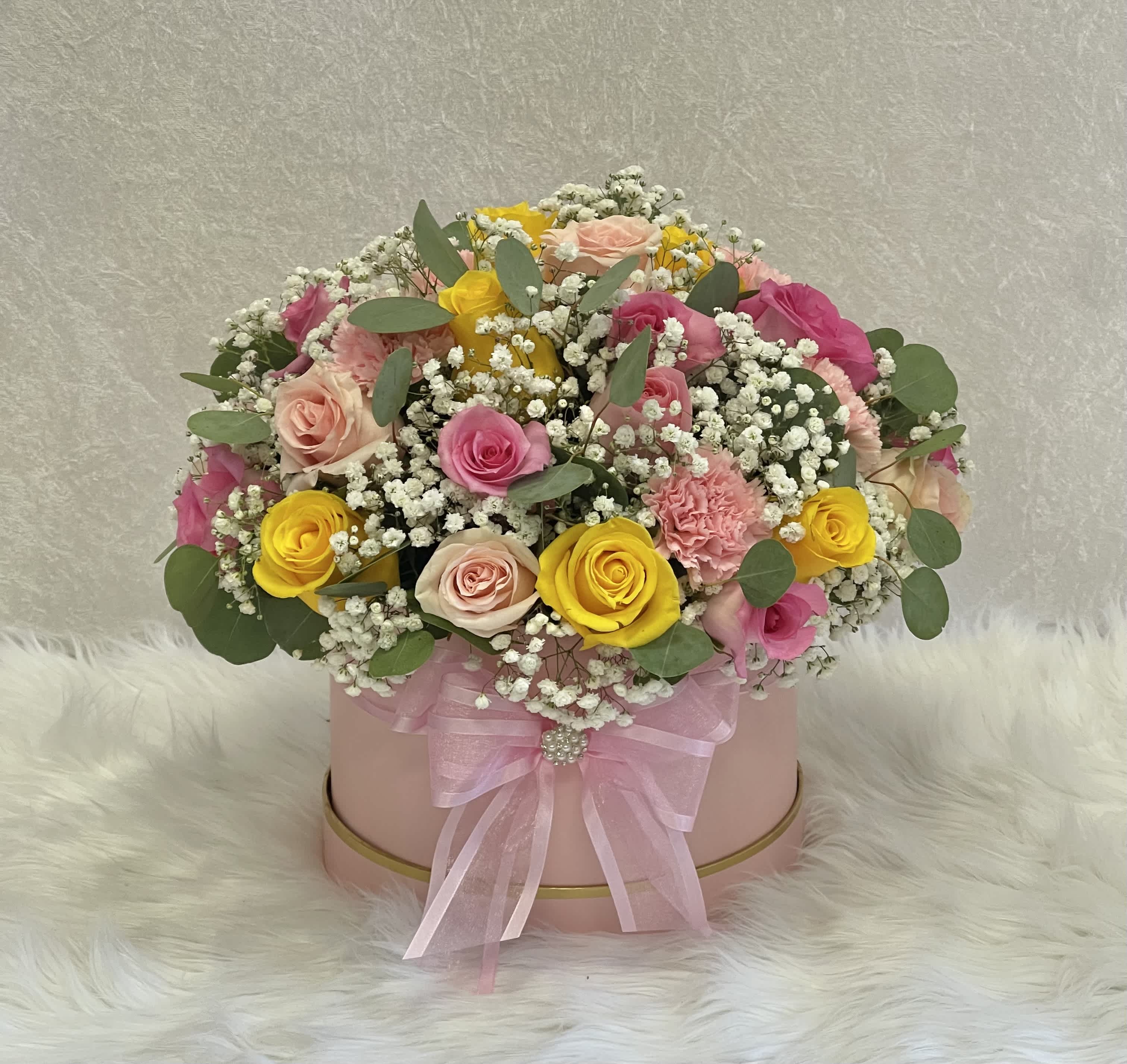 Pink hatbox arrangement with roses, carnations, and baby's breath