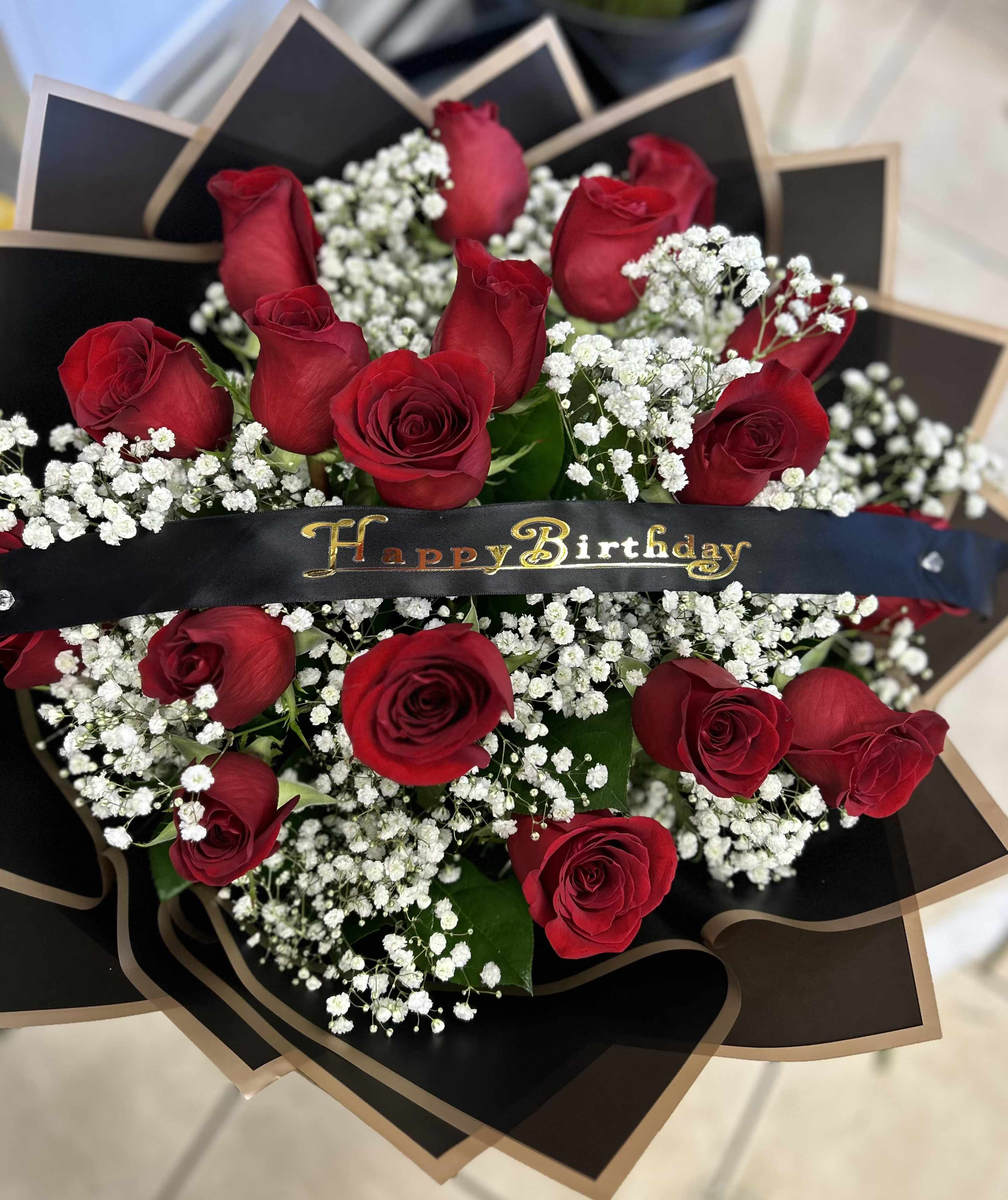 Bouquet of red roses with white baby's breath and a Happy Birthday ribbon