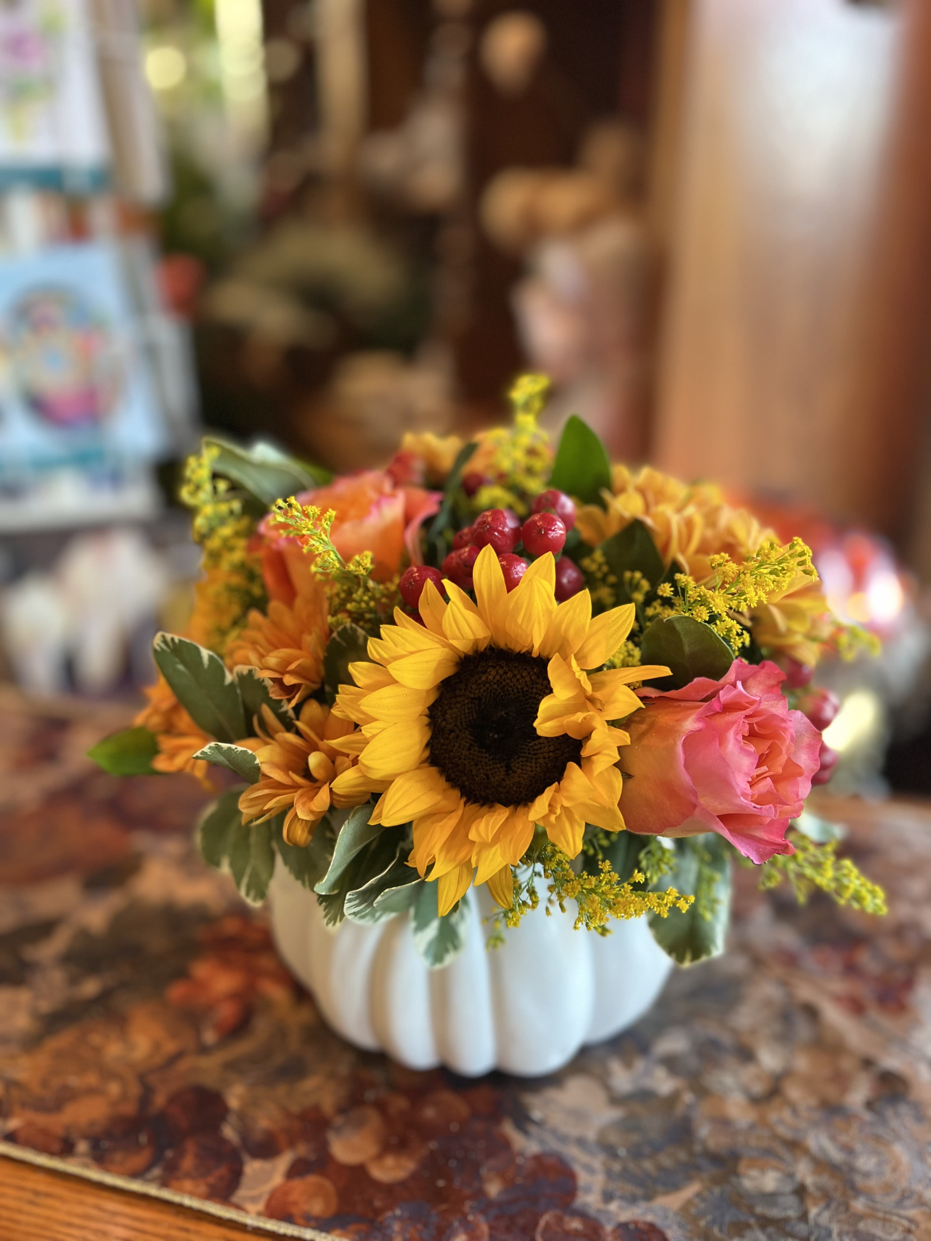 Autumn Spice Pumpkin - Sunflowers, orange roses, solid aster, red hypericum berries, daisy poms, thoughtfully arranged in an elegant ceramic white pumpkin.