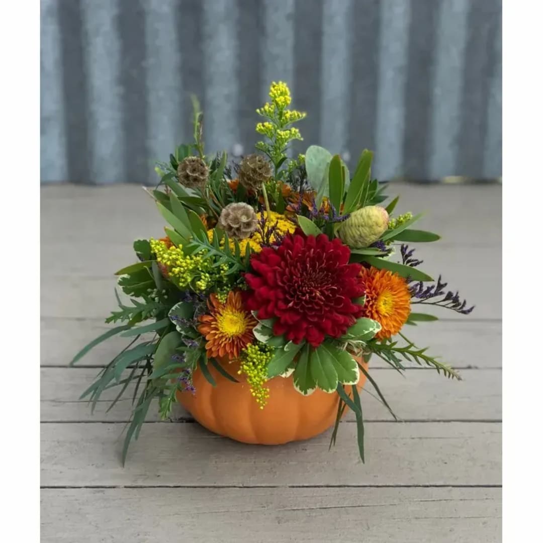 Autumn floral arrangement in an orange pumpkin container