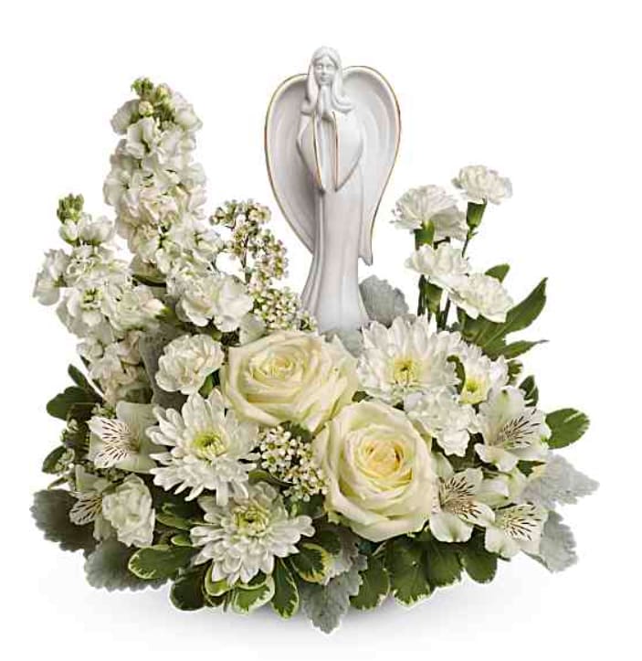White floral arrangement with an angel figurine centerpiece