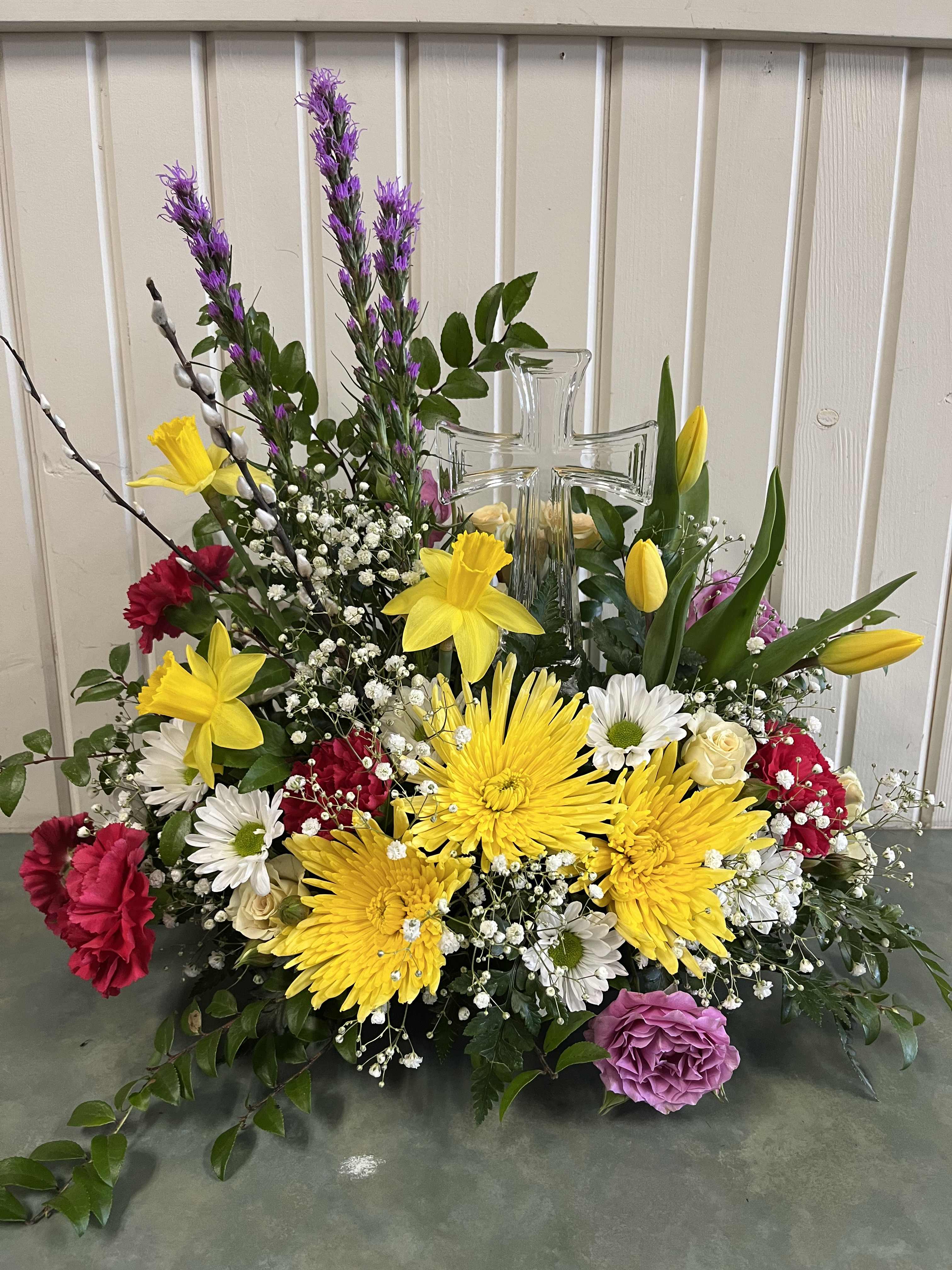 Colorful floral arrangement with a clear glass cross centerpiece