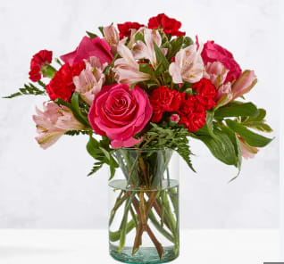 Pink and red mixed bouquet in a clear glass vase