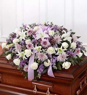 Lavender and white floral spray on a wooden casket