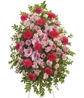 Standing spray of pink and red flowers with greenery