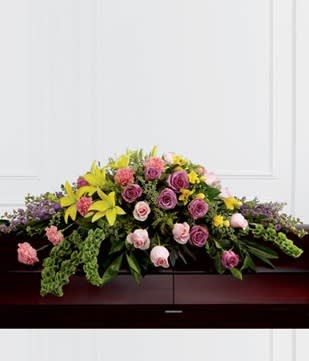 Casket spray with pink and purple roses and yellow lilies
