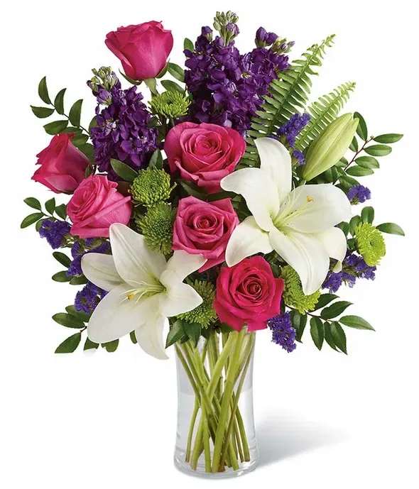 Pink roses and white lilies in a clear glass vase