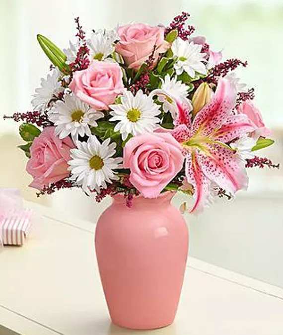 Pink roses and lilies in a pink vase with white daisies