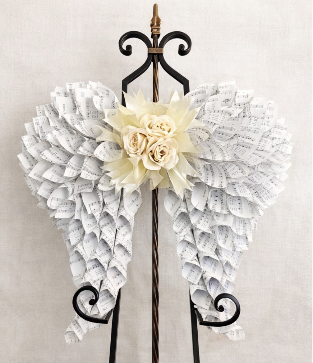 Angel Wings 24"x24" Floral Center - 24” x 24” angel wings made of hymnal pages with floral blooms and ribbons at the center. Can be hung of a wall or displayed on an easel in the home, the perfect way to honor a loved one. 