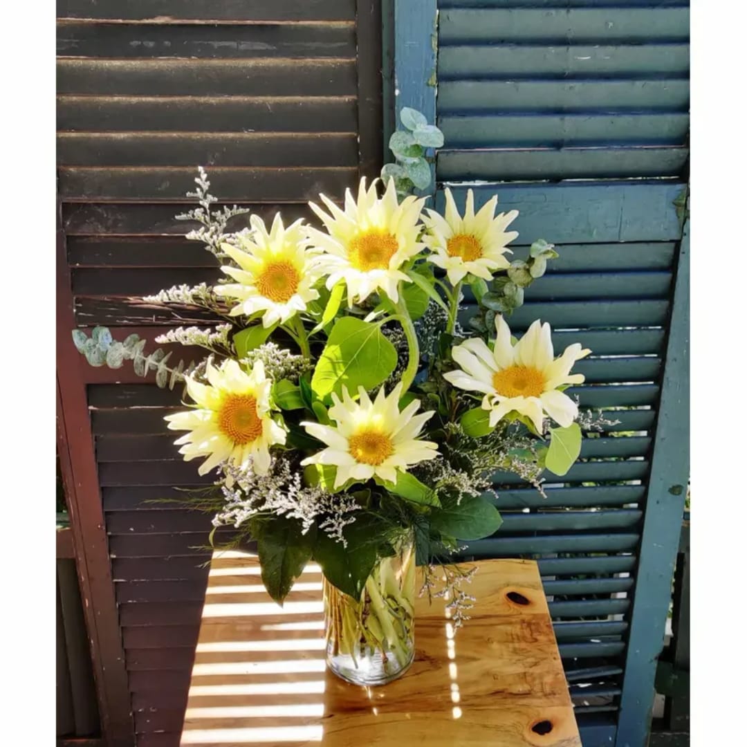 Bouquet of pale yellow daisies in a clear glass vase