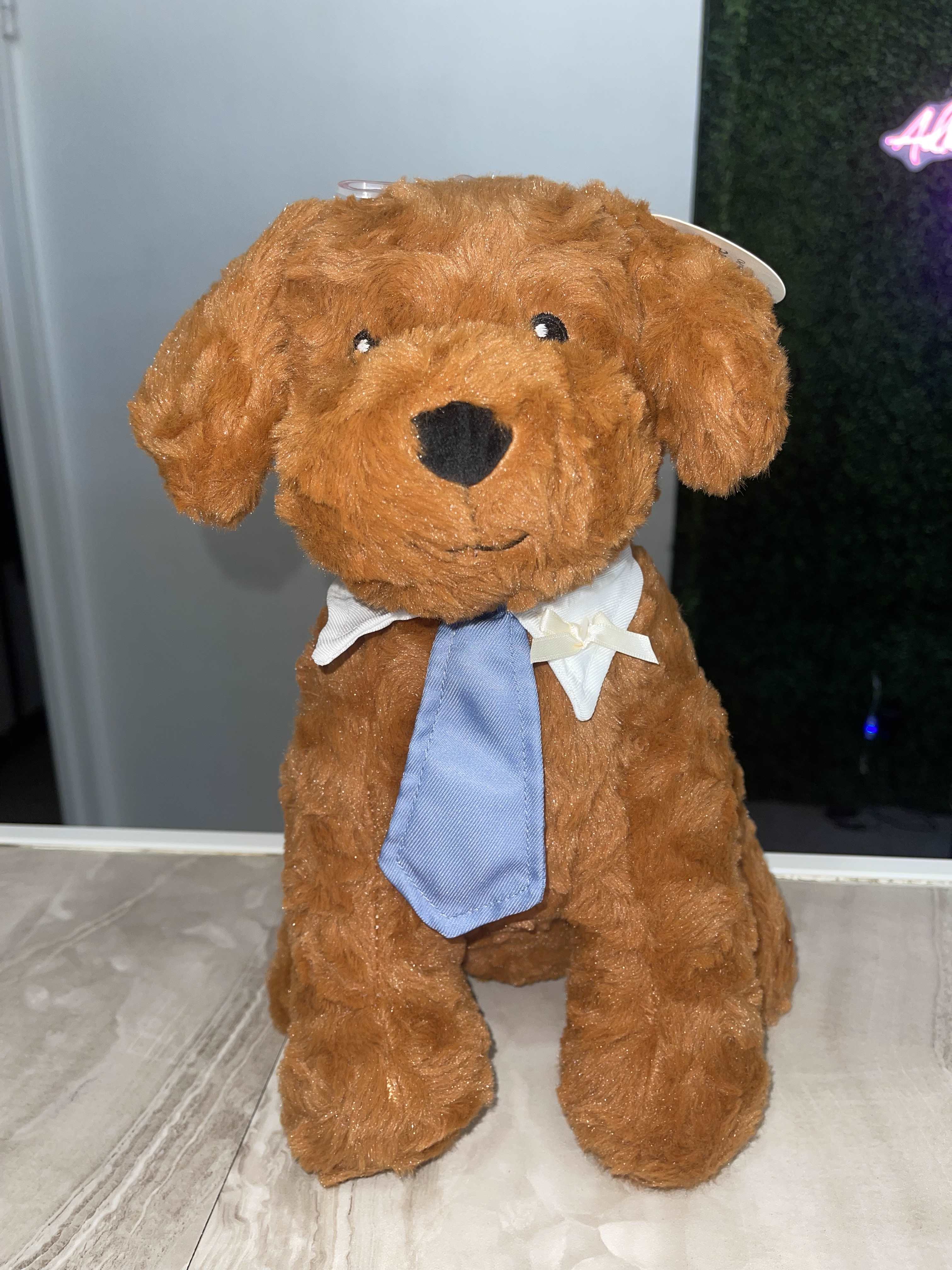Brown plush dog wearing a blue tie and white collar