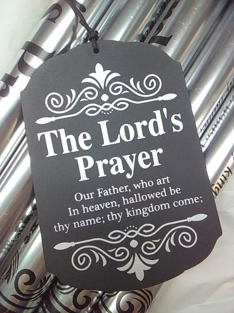 Black prayer tag hanging on silver wrapped gift packaging