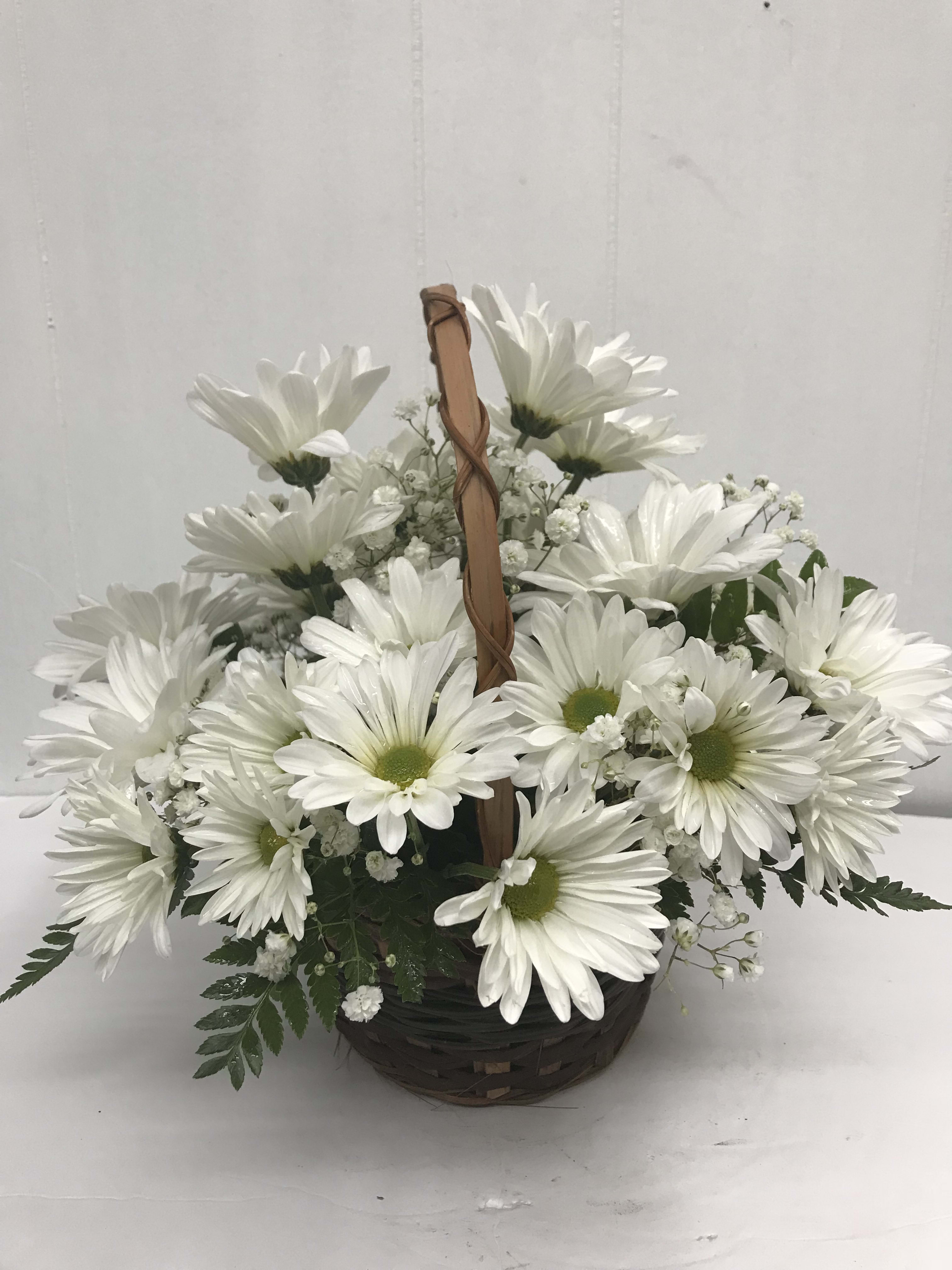 White daisy bouquet in a woven basket with a handle