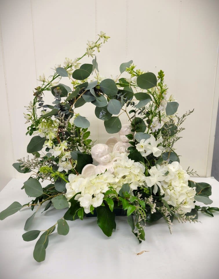 White floral wreath with eucalyptus and angel figurines