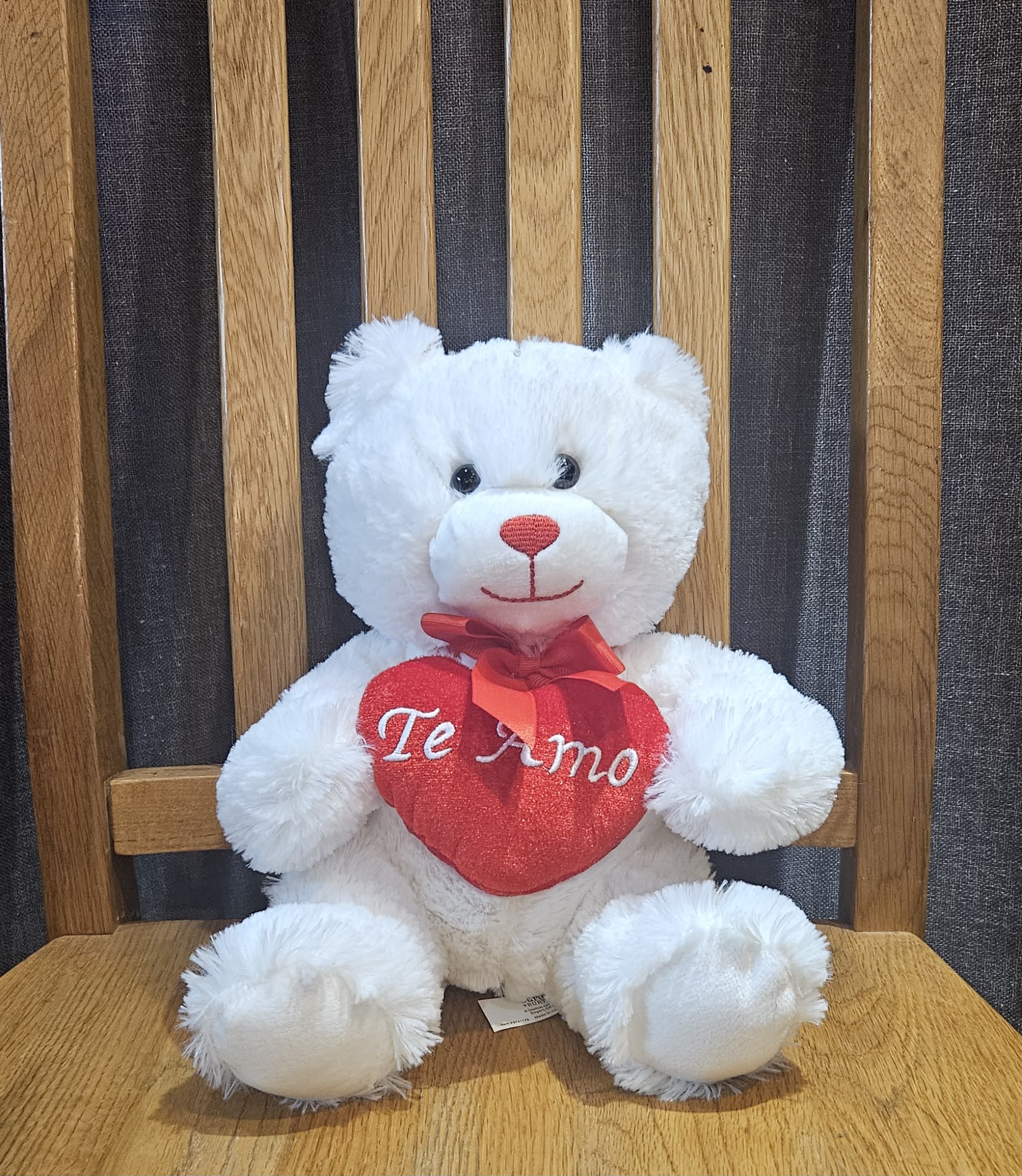 White teddy bear holding a red heart with "Te Amo" text