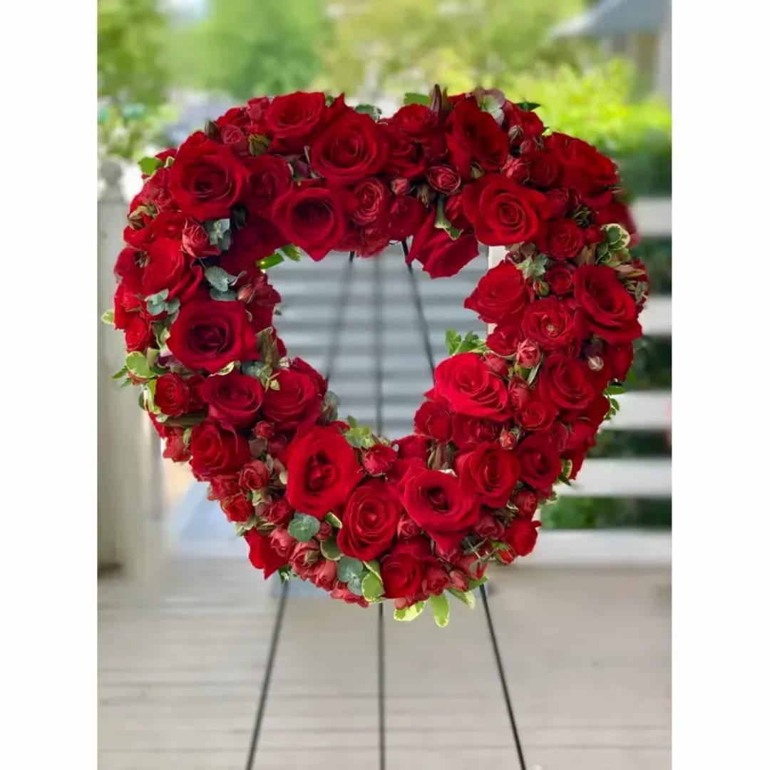 Heart-shaped arrangement of red roses on a stand