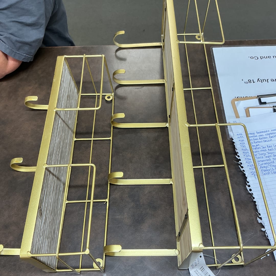 Gold metal display racks on a table with papers nearby