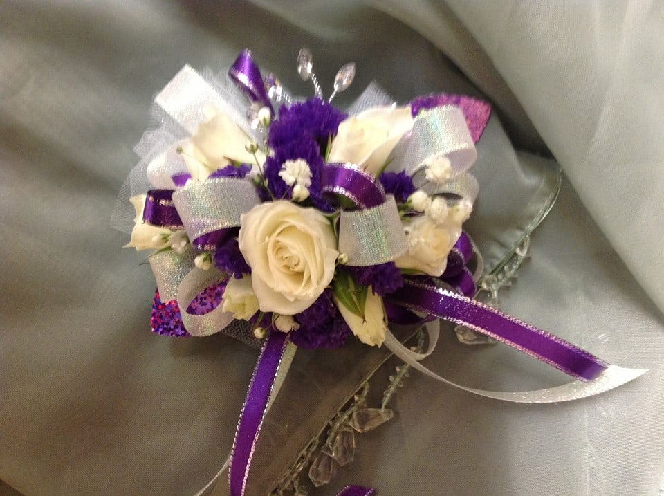 White roses and purple flowers with silver and purple ribbons